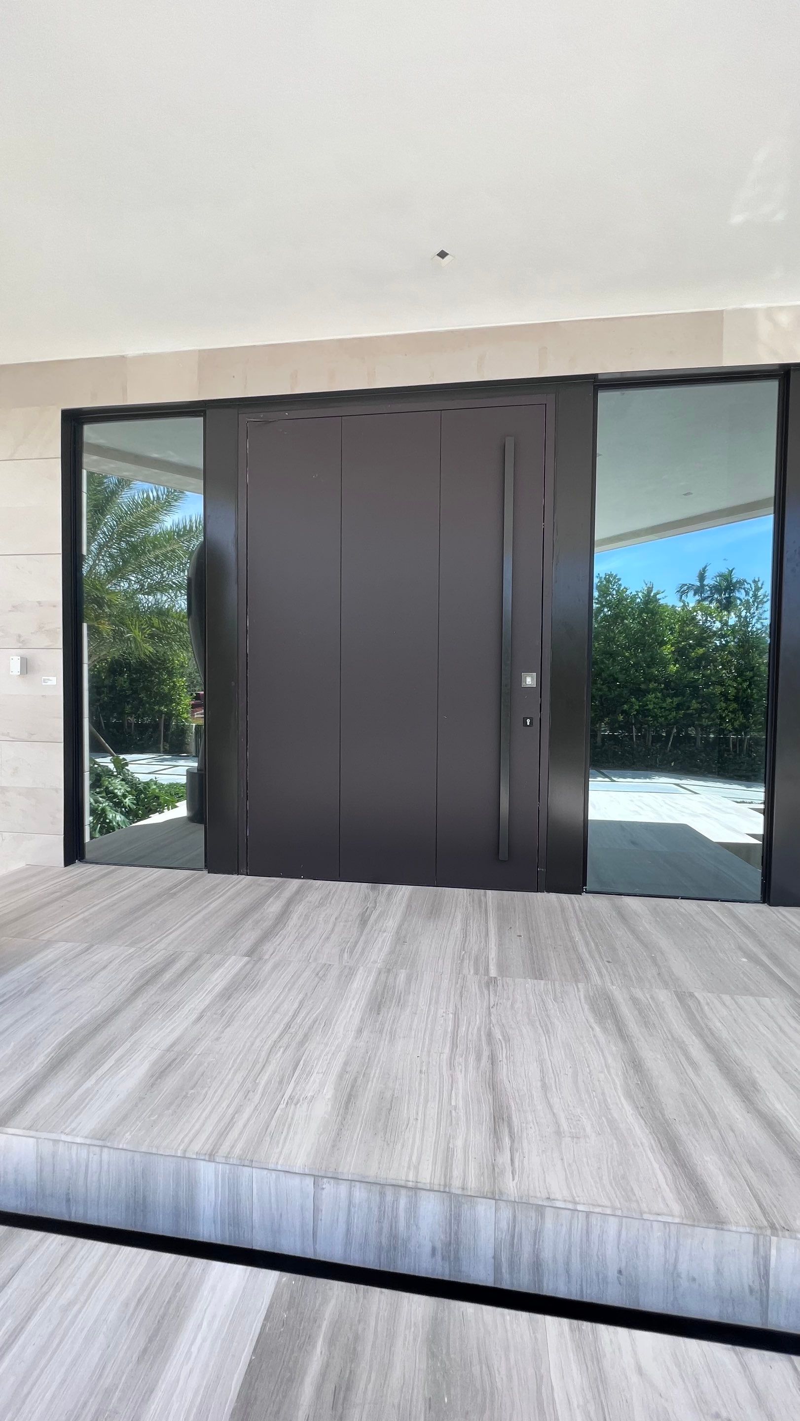 Custom Material Pivot Door installation by Impact Precious Wood Inc.