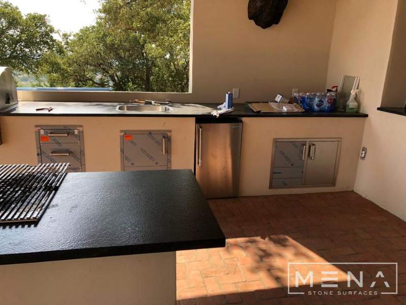 Kitchen, outdoor kitchen and pool brick floor installation by Mena stone surfaces