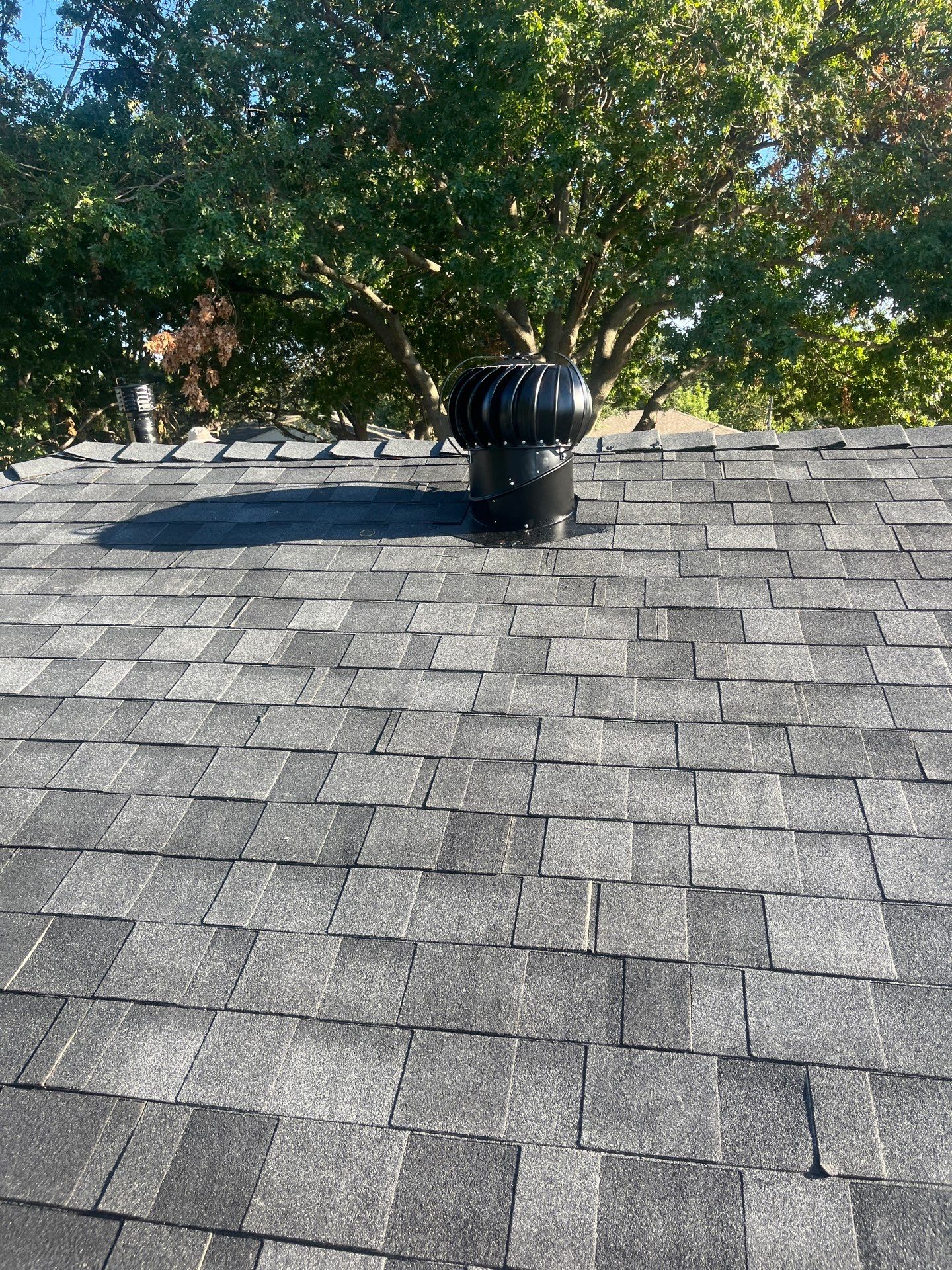 White brick/light gray shutters with IKO Granite Black  by Tejas Roofworks + Restoration