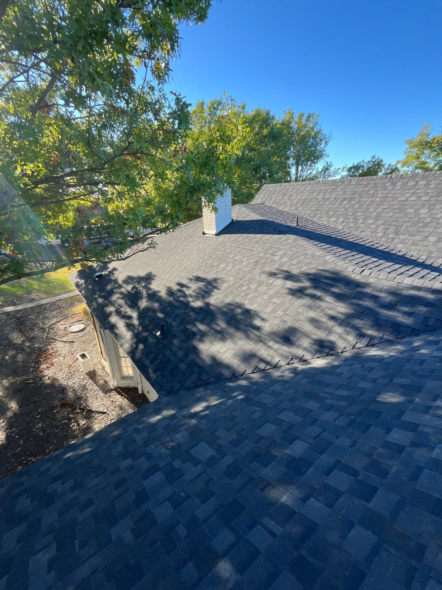 White brick with IKO Granite Black by Tejas Roofworks + Restoration