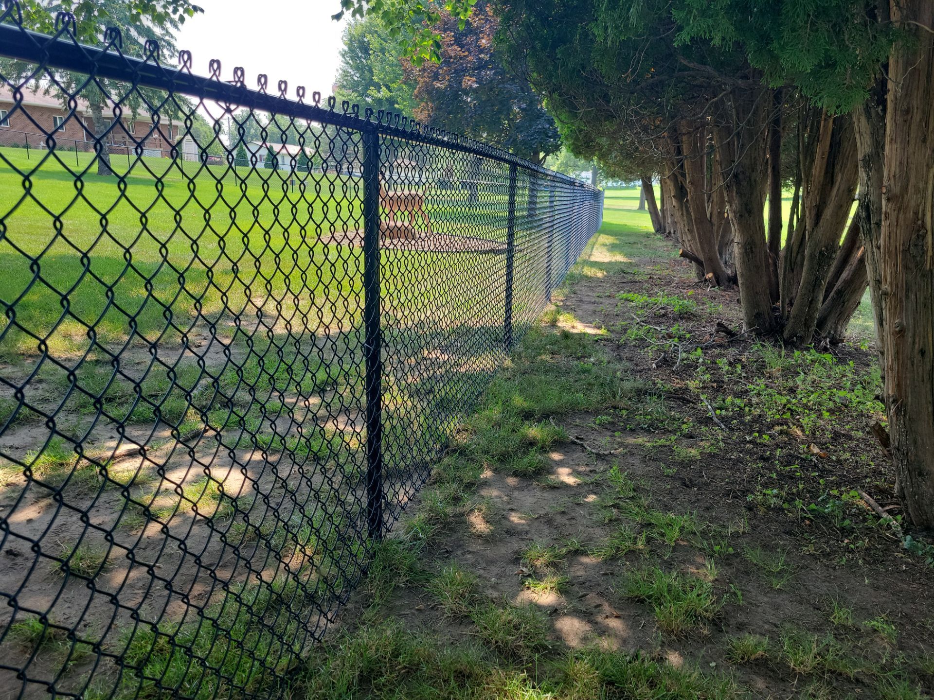 Black Vinyl-Coated Chain Link Fence Installation in New Hampton by Perfect Picket Fence and Stain