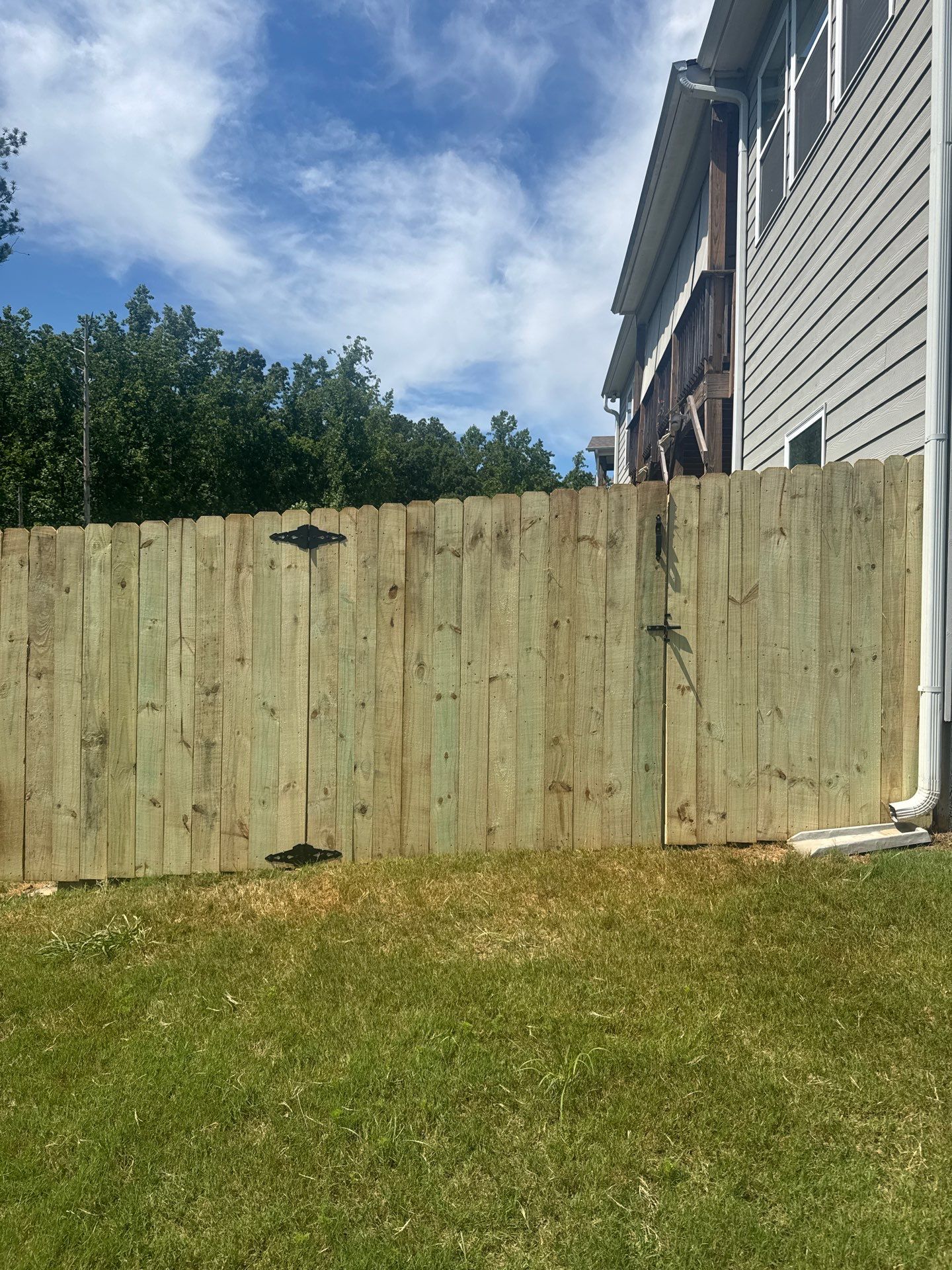 Ground-Level Gray Composite Deck and Privacy Fence Installation by Swift Home Renovations