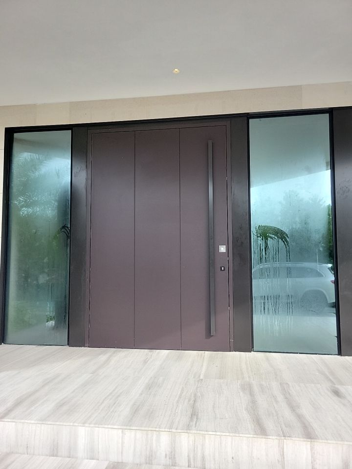 Custom Material Pivot Door installation by Impact Precious Wood Inc.