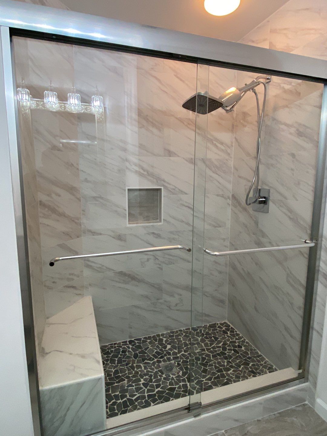 Bathroom Remodel using porcelain tiles , wood make vanetys , mirross , bathroom accessories  by Jesus Master Handyman LLC 