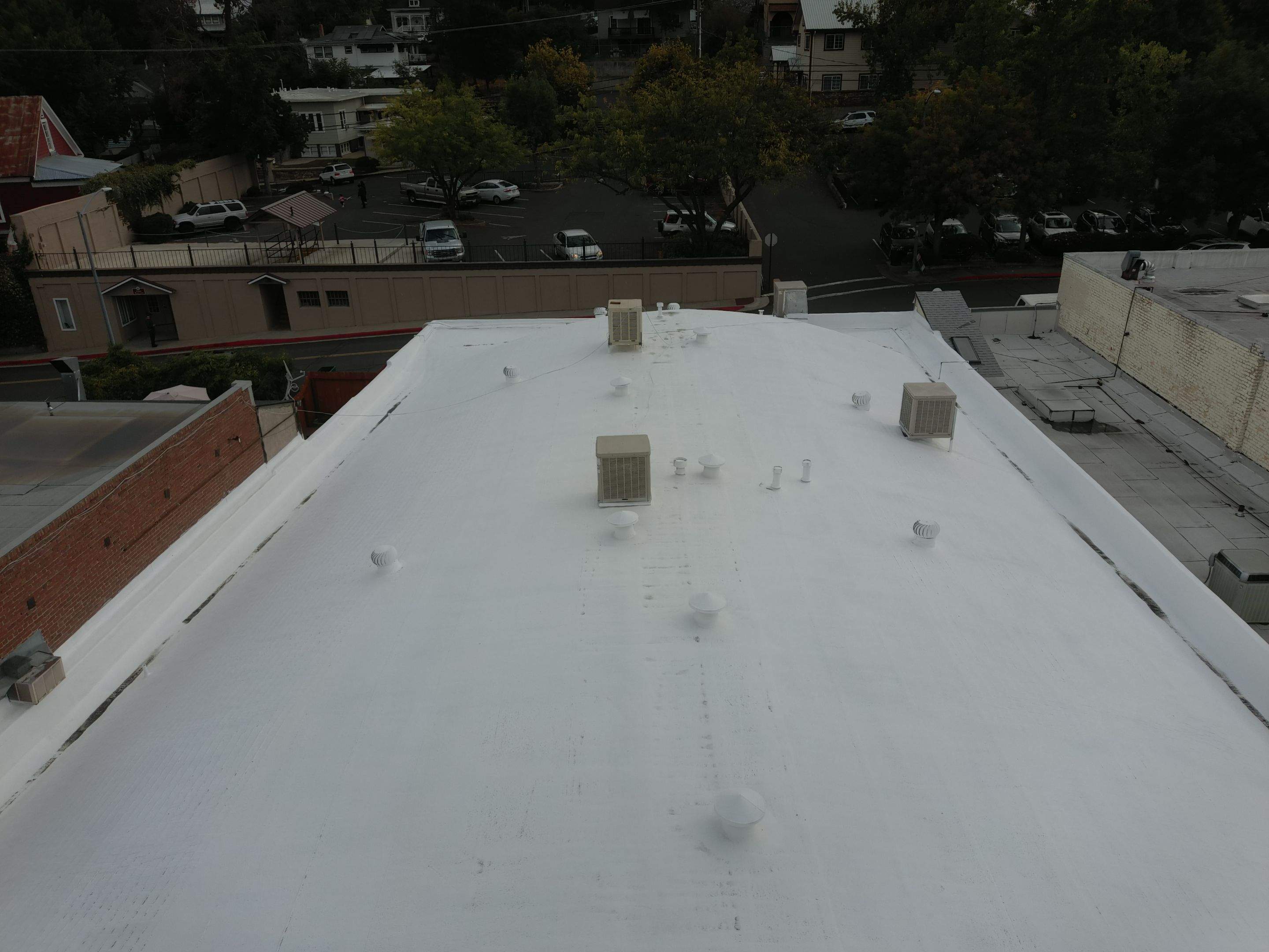 Foam and coatings on commercial roof by Straight Edge Roofing Inc