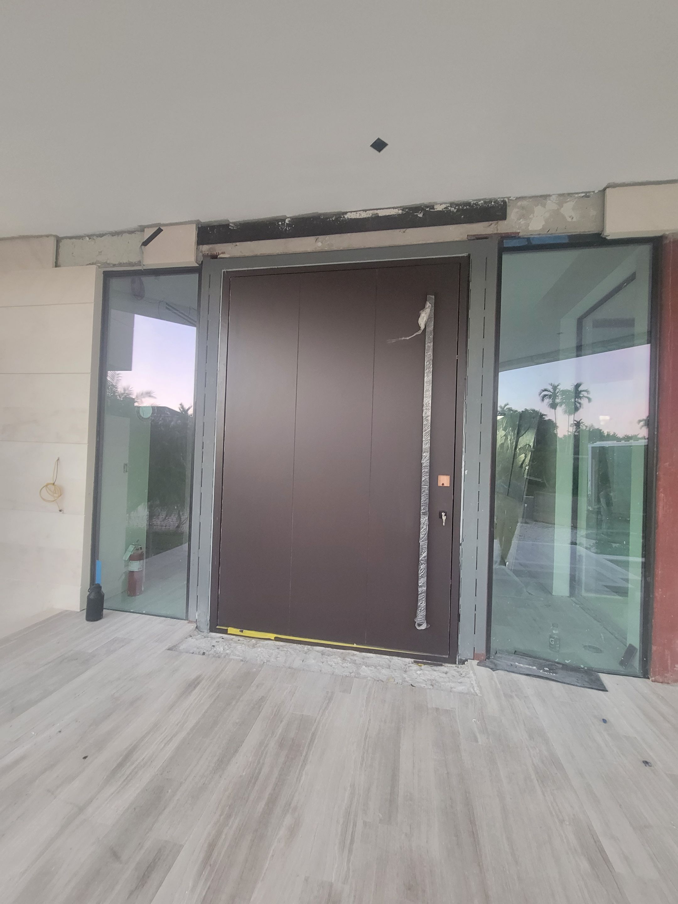 Custom Material Pivot Door installation by Impact Precious Wood Inc.