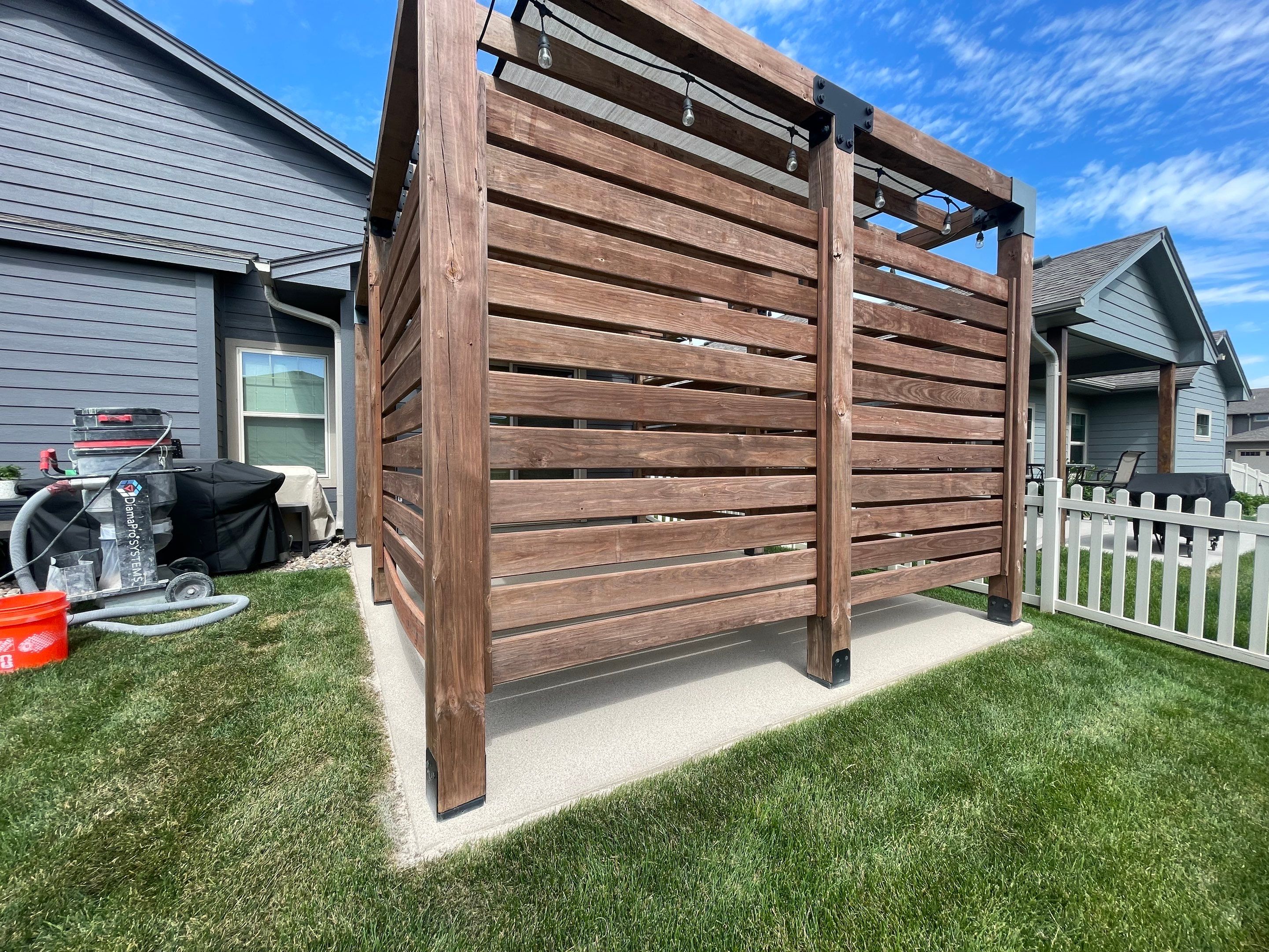 Textured Concrete Patio Coating and Custom Privacy Pergola in Sioux Falls by Select Painting, Coatings & Garage Cabinets