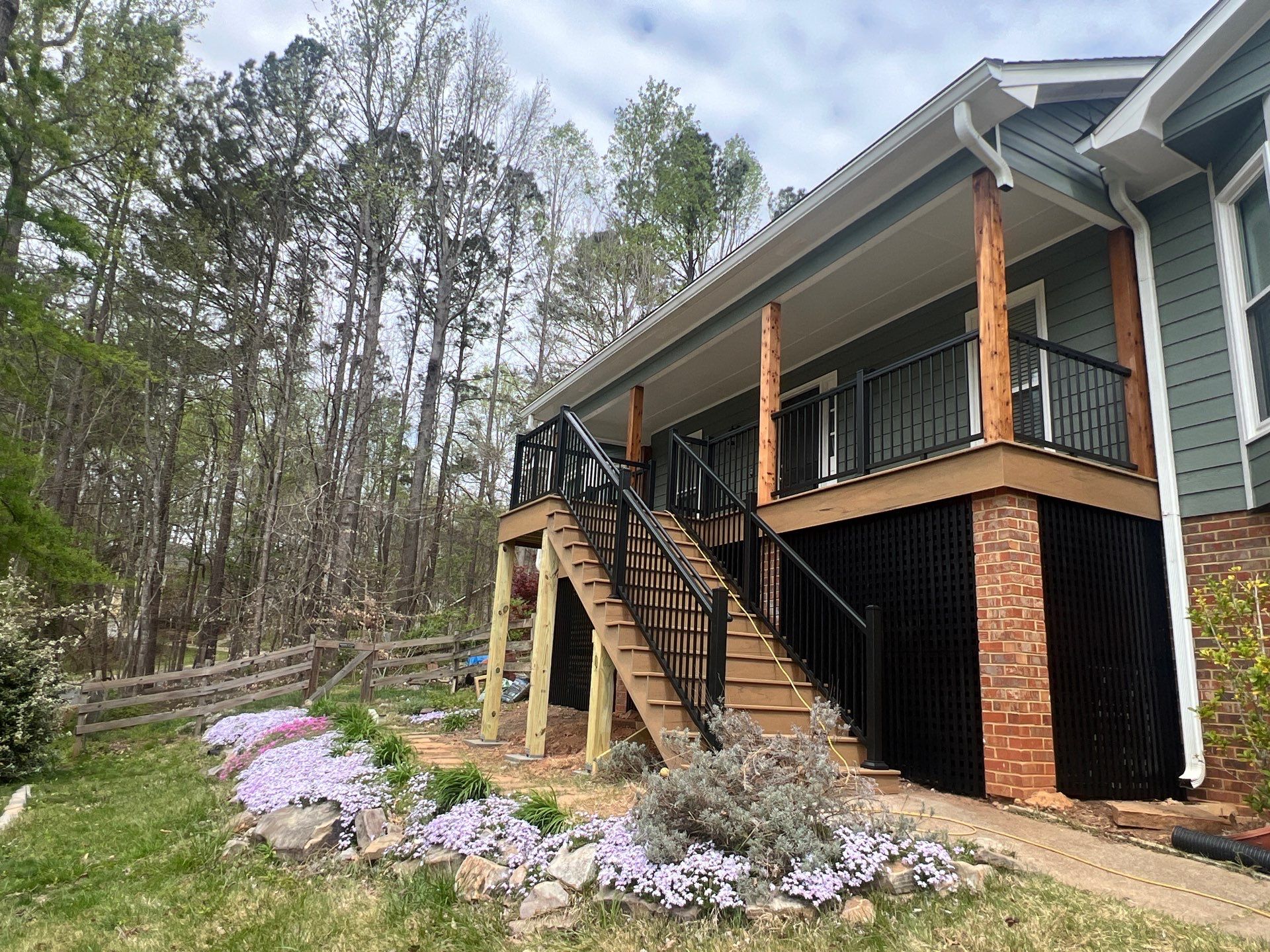 Composite Deck and Porch Renovation With Black Metal Railings by Swift Home Renovations 