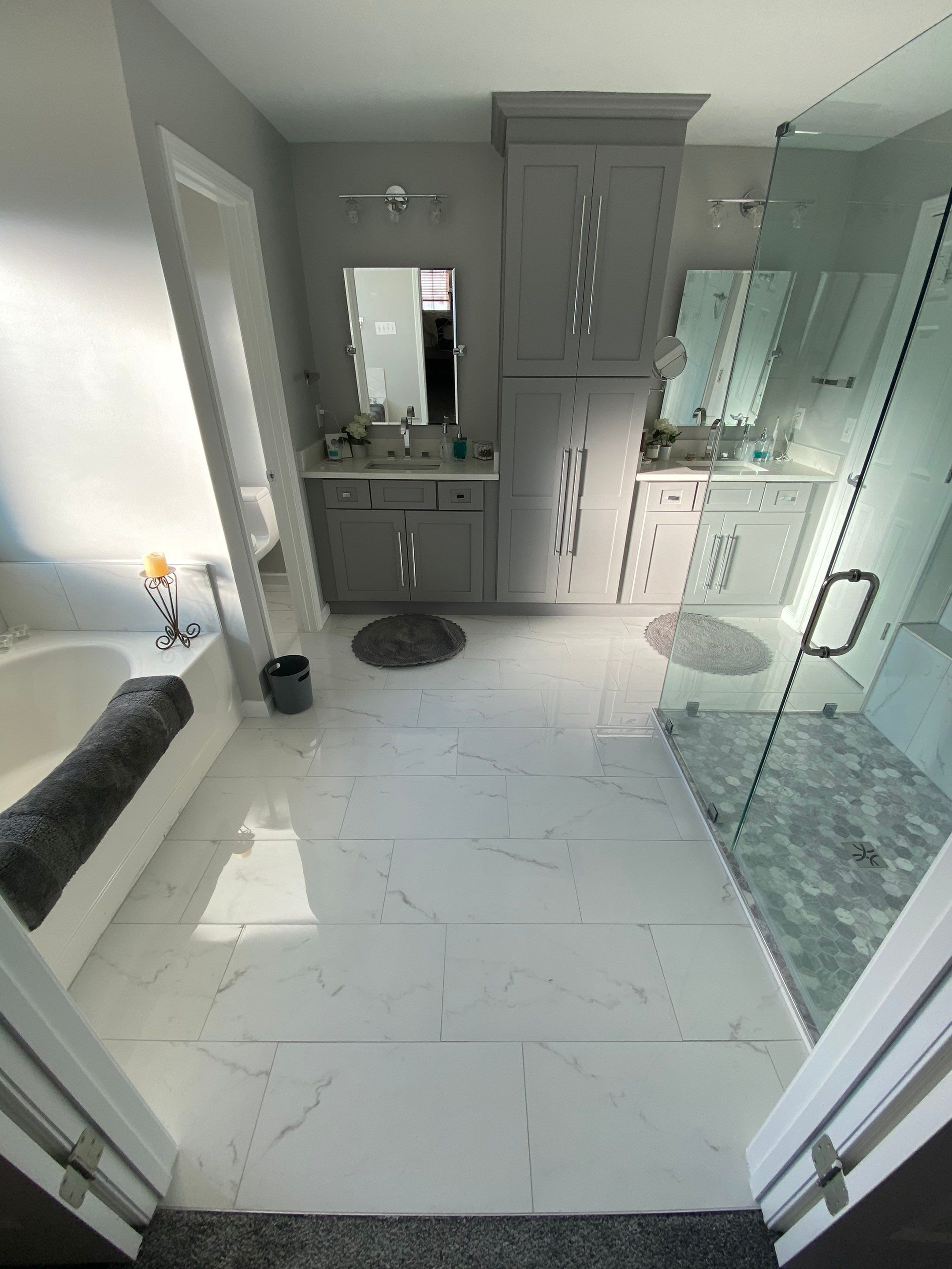 Master Bathroom Renovation Featuring Marble-Look Tile and Frameless Glass by Swift Home Renovations