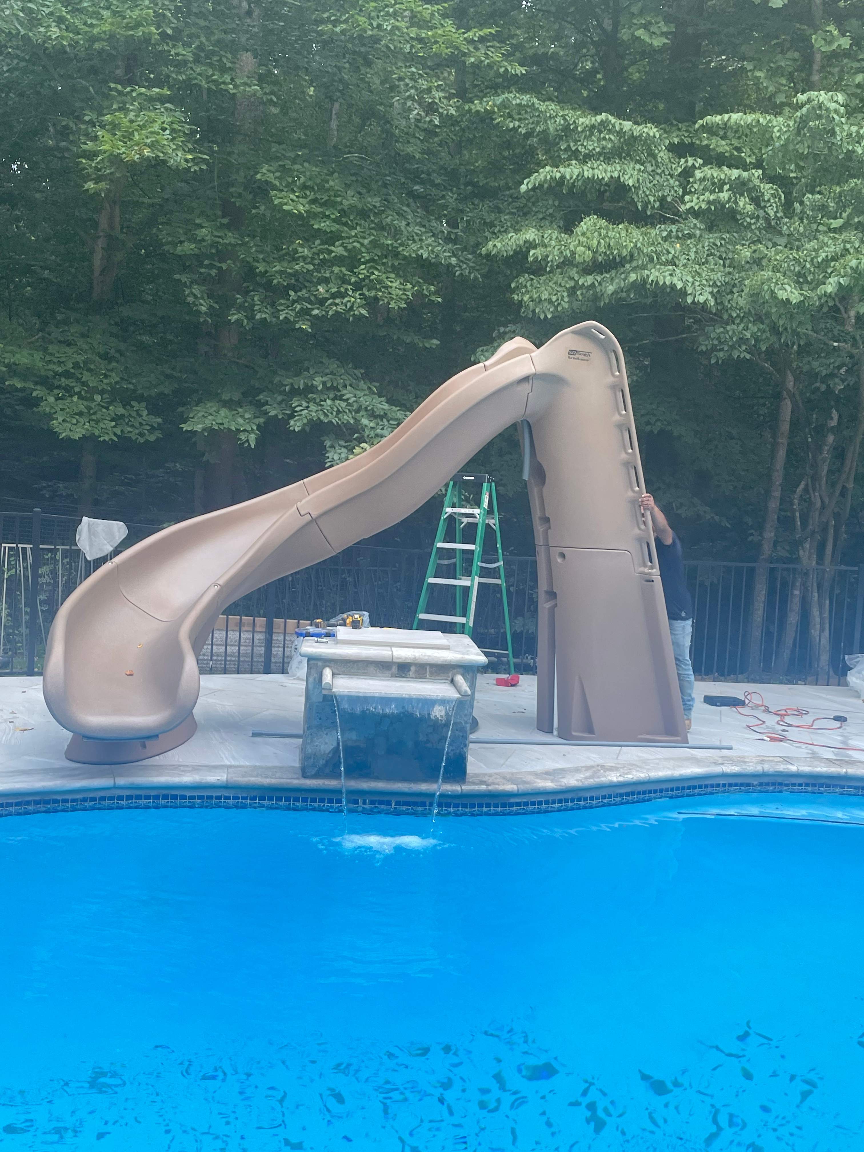 Pool Surround remodel with retaining walls, new waterfall and water slide by Fairfax Contractors, LLC