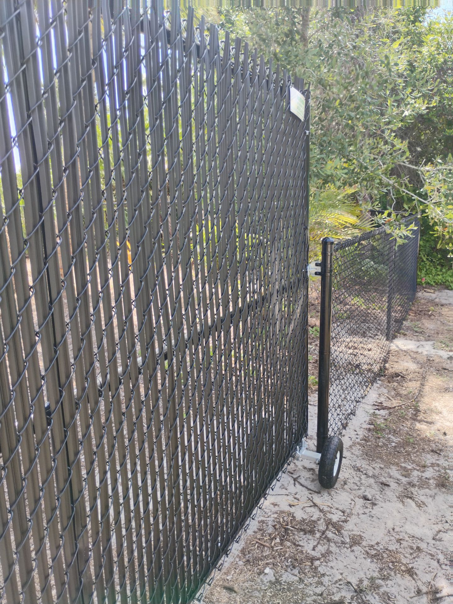 Black Vinyl-Coated Chain Link Fence and Rolling Gate Installation in North Port by True Fence LLC