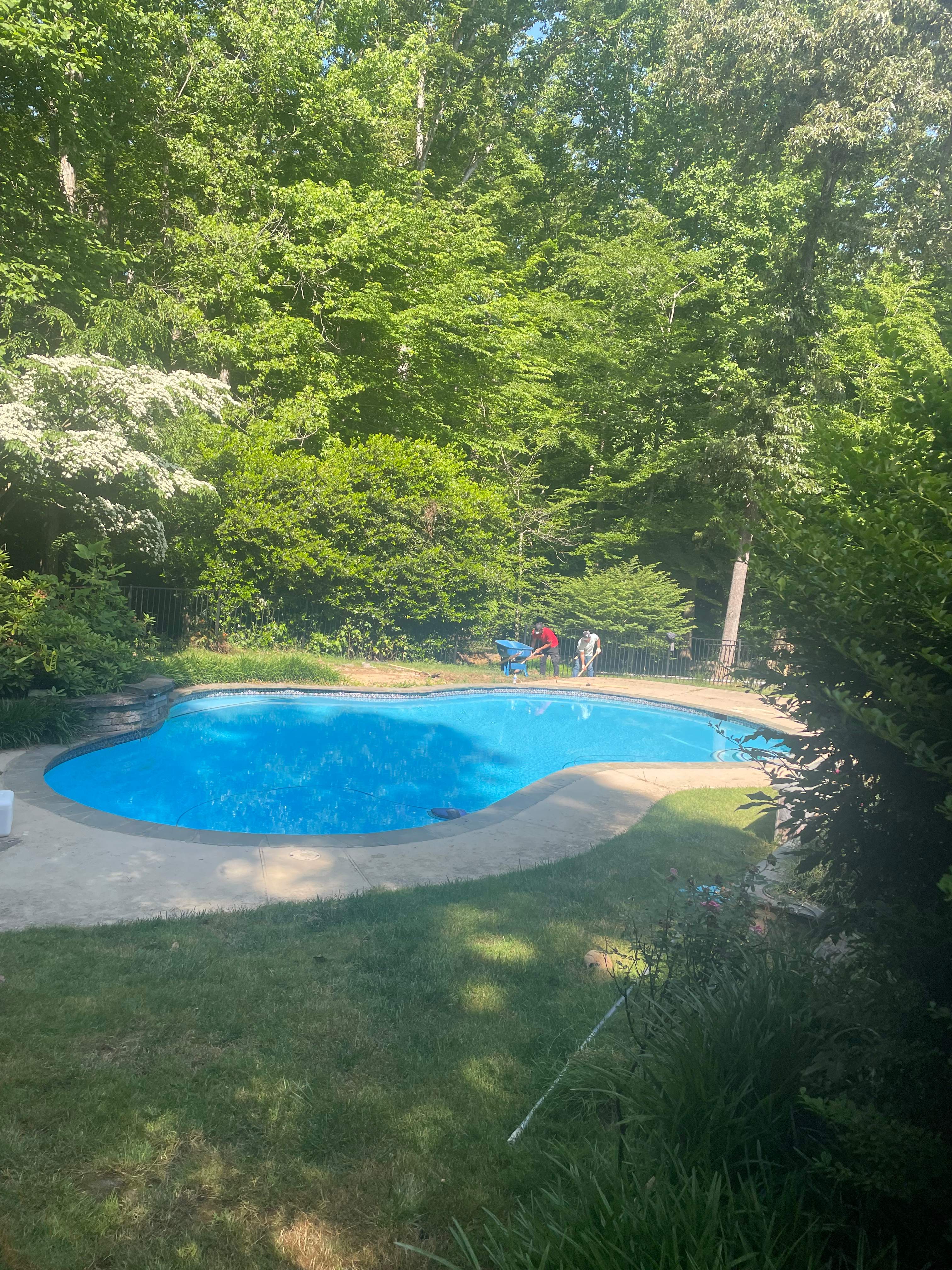 Pool Surround remodel with retaining walls, new waterfall and water slide by Fairfax Contractors, LLC