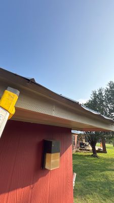 Completed metal roof on a red building exterior.