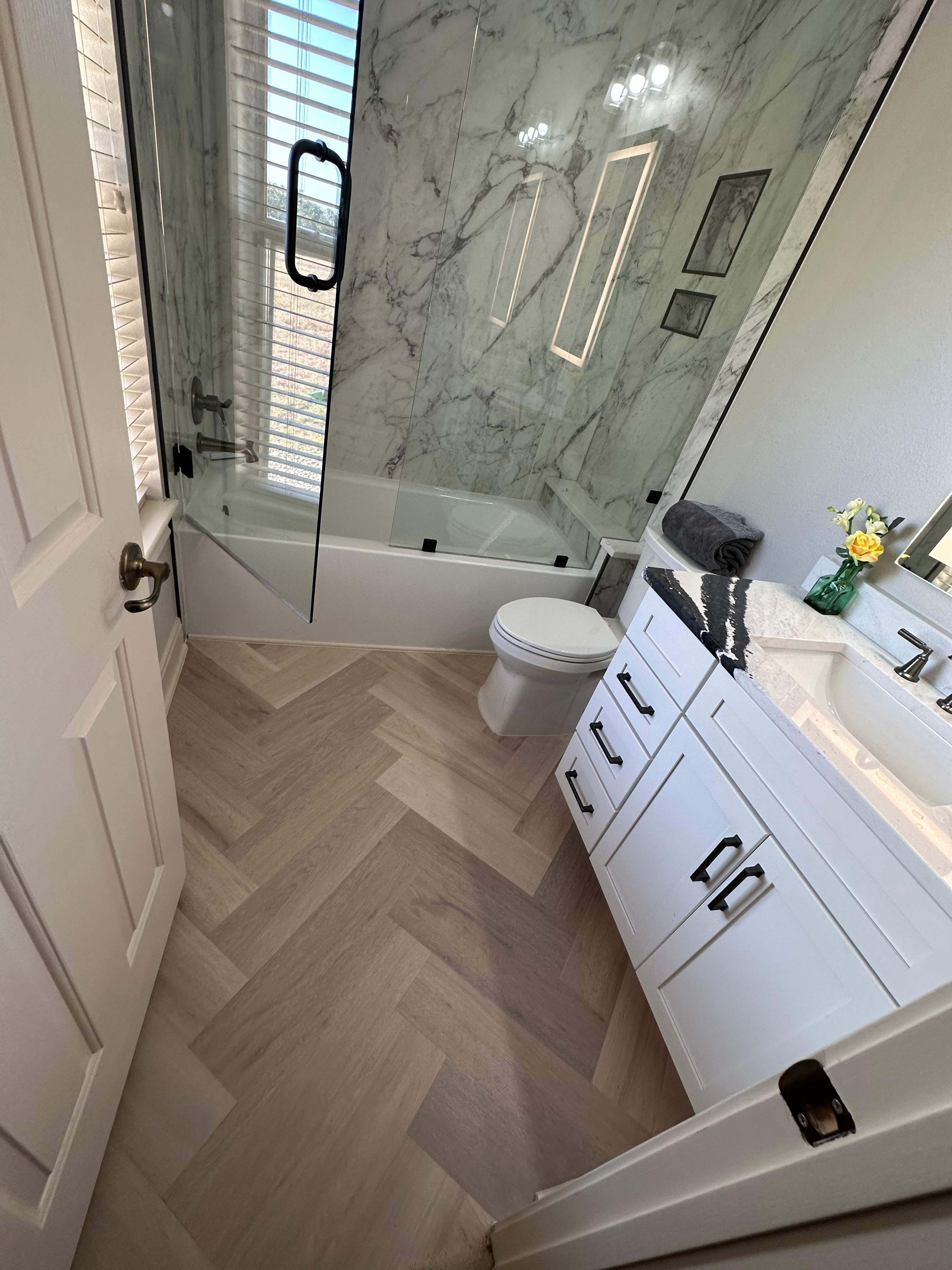 Boerne Guest Bathroom Remodel with Marble Tub Surround & Herringbone Flooring by Legacy Bath and Kitchen
