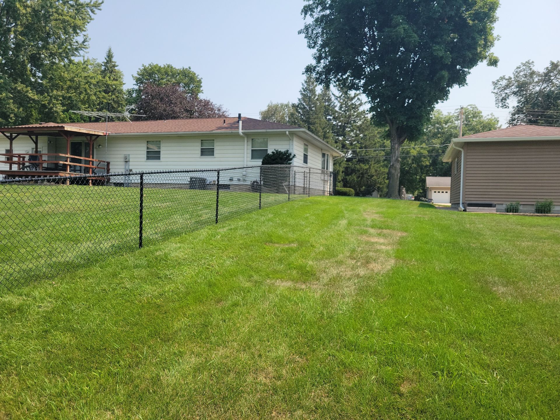 Black Vinyl-Coated Chain Link Fence Installation in New Hampton by Perfect Picket Fence and Stain