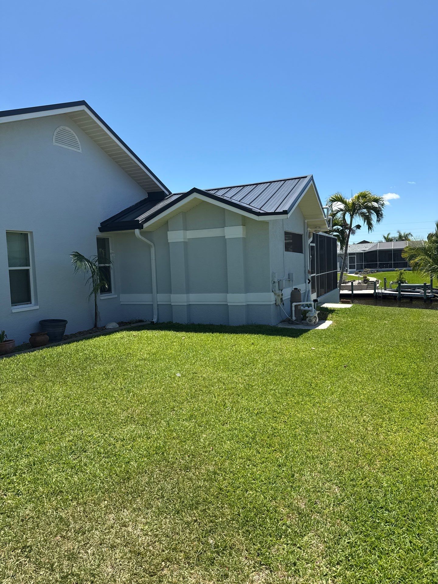 Black Seamless Gutters and White Downspouts in Cape Coral FL by Gutter Professors