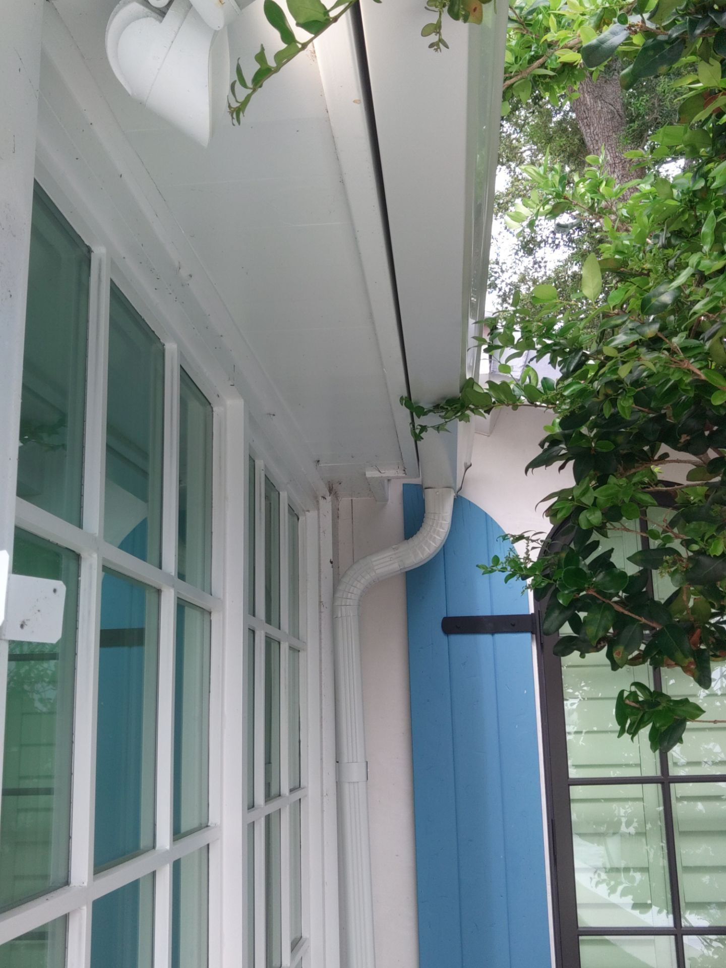 Seamless aluminum gutter installation in Sarasota, FL using 3x4 elbow downspouts combined with round downspouts by Gutter Professors