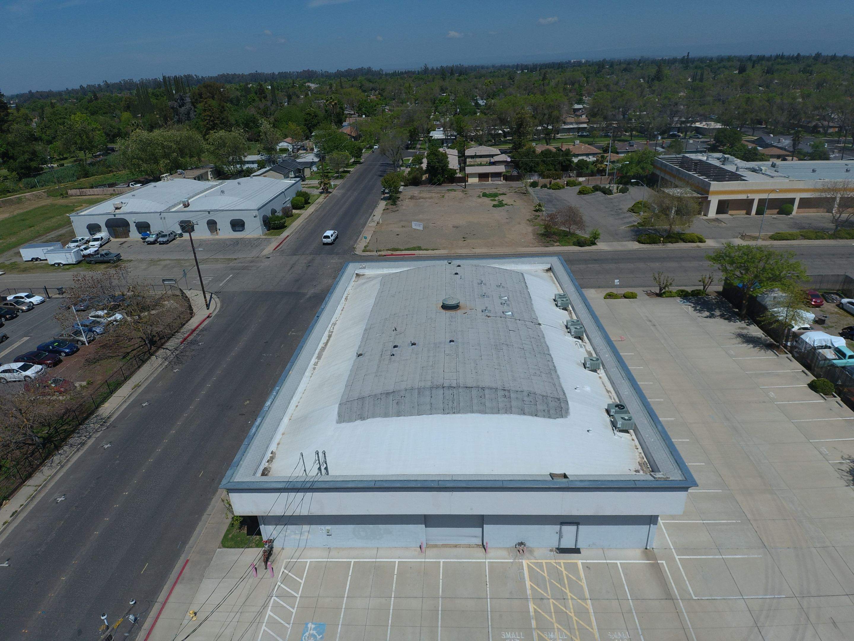 Spray foam and coatings using Conklin Benchmark/PUMA XL coatings on Auto Body Shop by Straight Edge Roofing Inc
