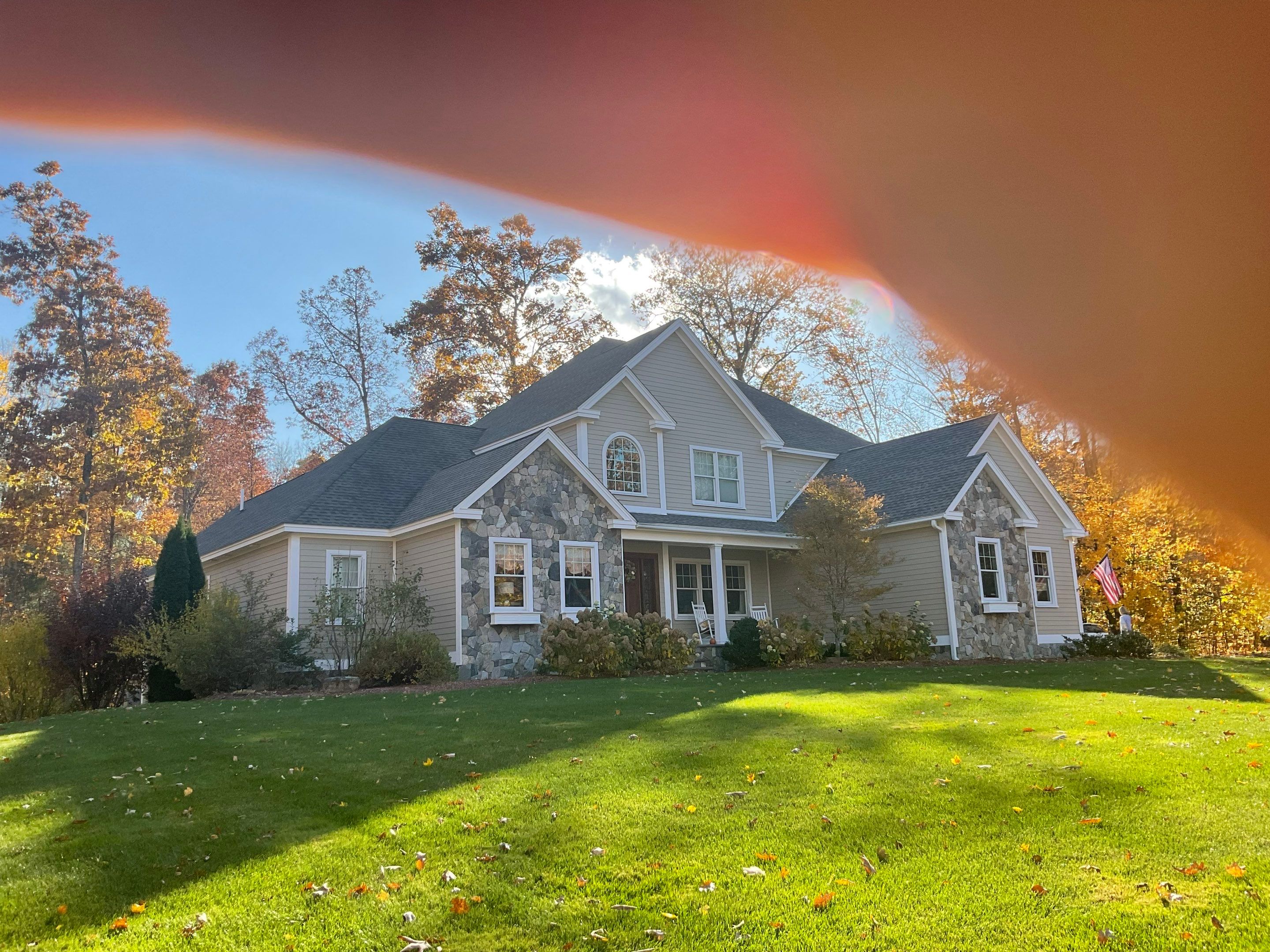 pressure washing service being performed on the exterior surfaces of the house with focus on cleaning the siding and stones