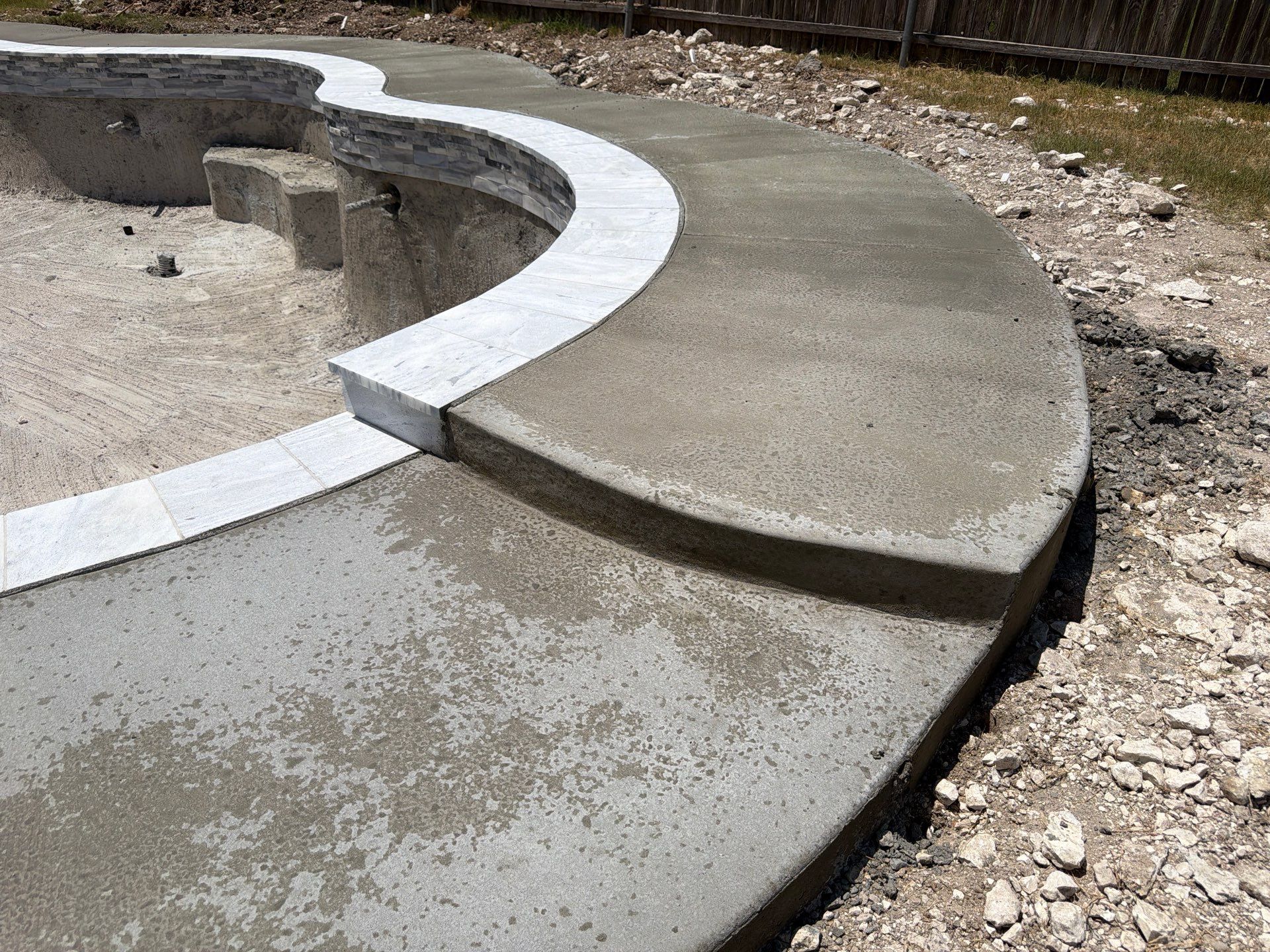 Freeform Pool with Tanning Ledge and Raised Stone Wall by Pinnacle Pools and Spas - DFW