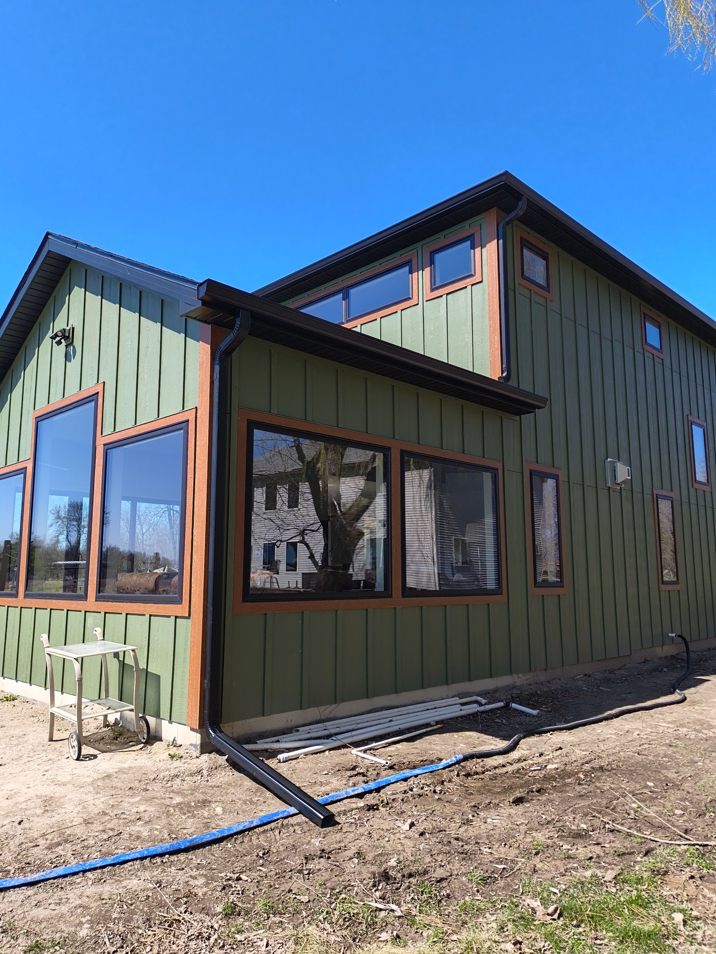 Seamless Gutter Installation in Annandale MN | 6” Black Gutters on Green Home by Next Level Seamless Gutters / Exteriors Inc.