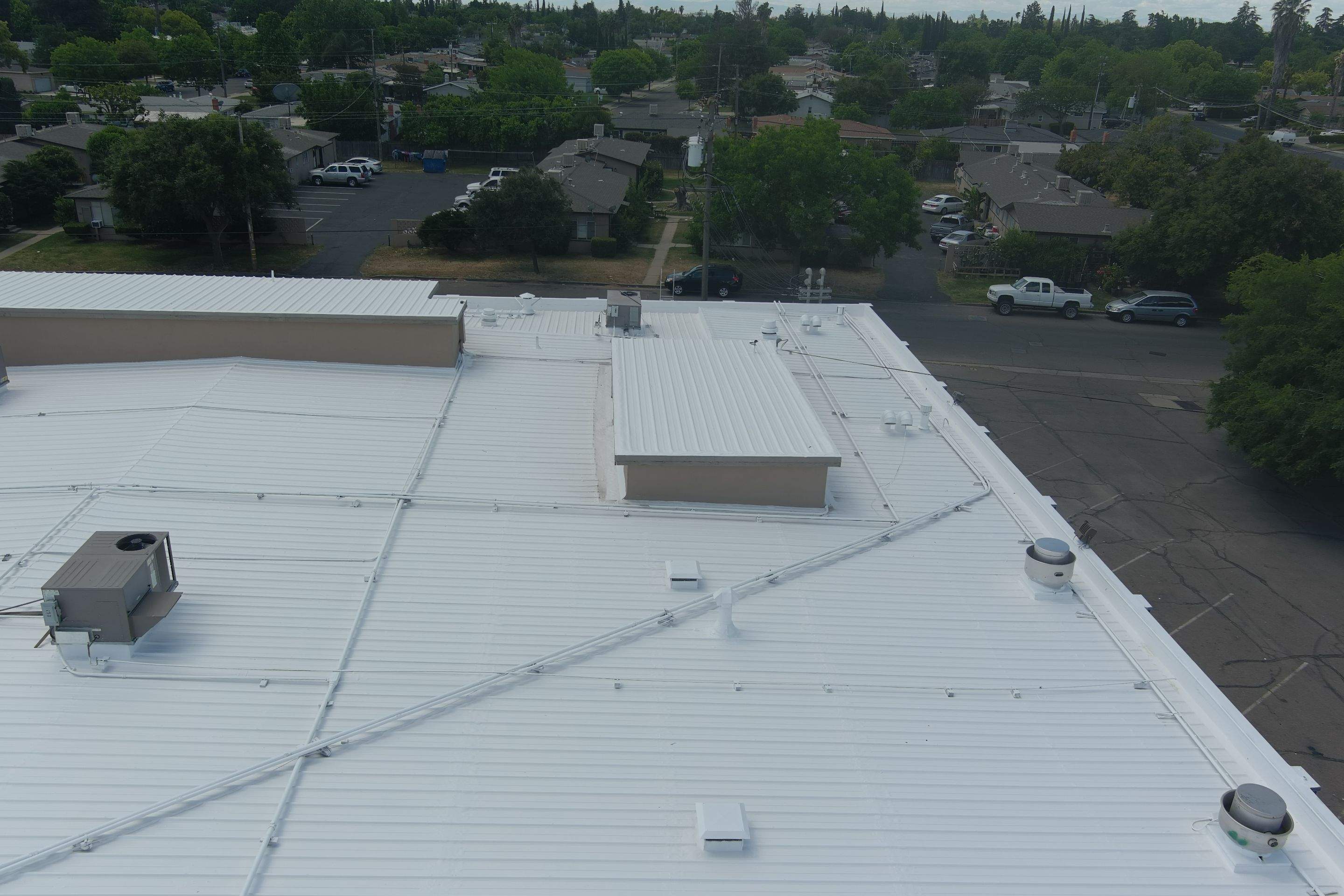 Metal roof restoration on commercial roof using Conklin Benchmark/ PUMA XL acrylic coatings over metal and foam by Straight Edge Roofing Inc