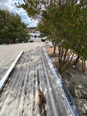 Corrugated metal roof edge with visible debris