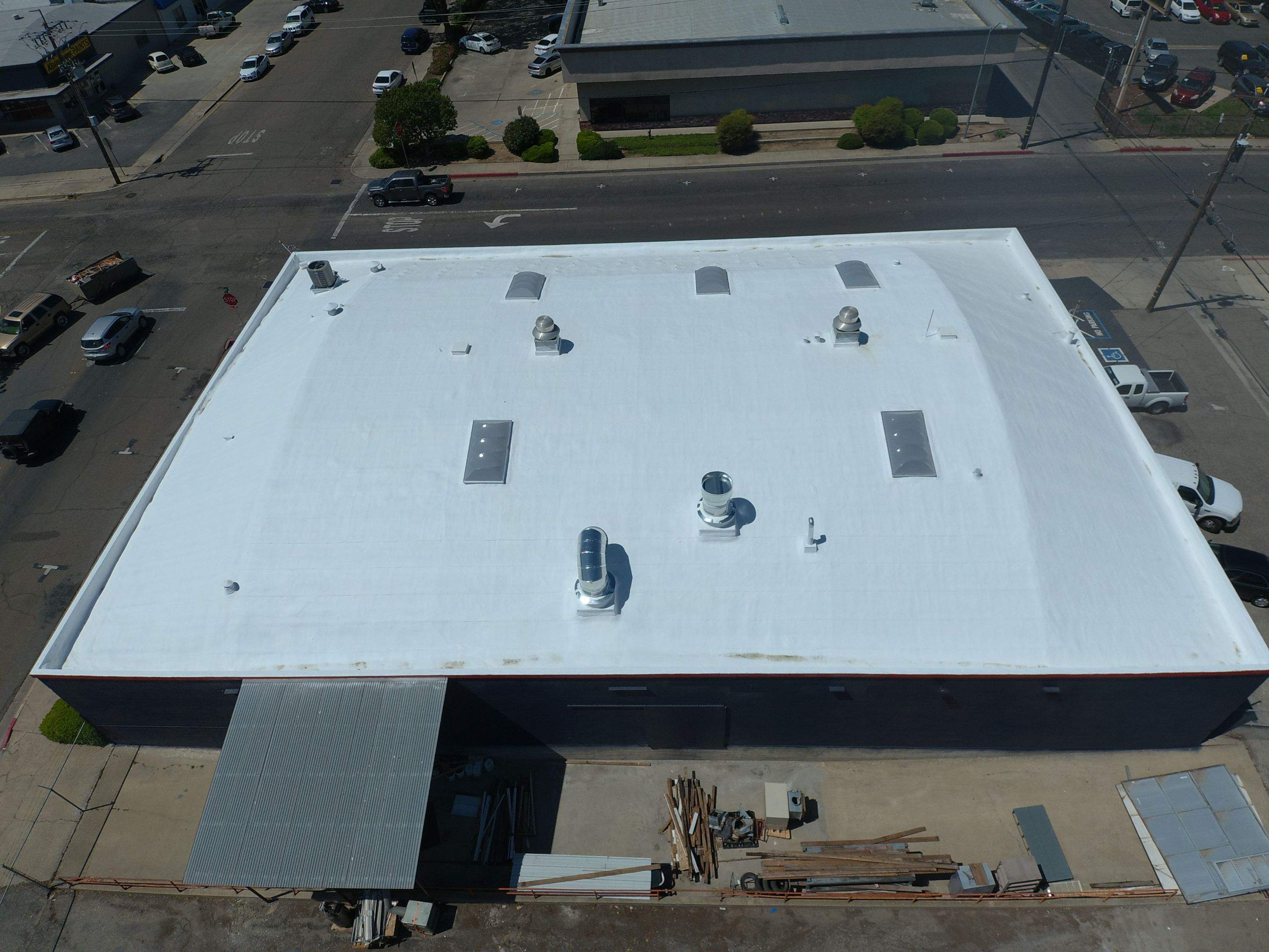 Spray foam and coatings using Conklin Benchmark/PUMA XL coatings on Auto Body Shop by Straight Edge Roofing Inc
