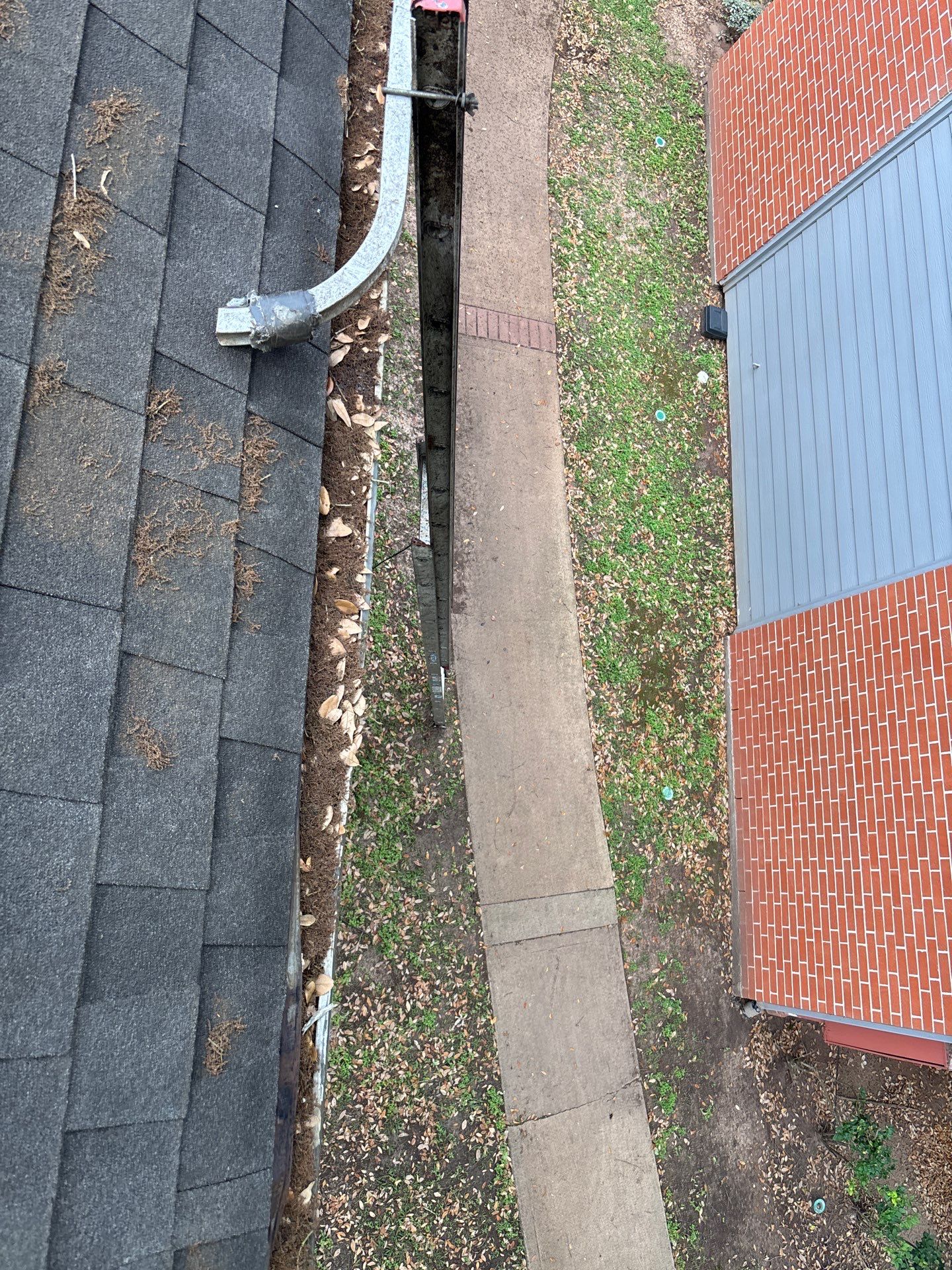 Commercial gutter cleaning Sugar Land & Katy, TX before photo with filled gutters
