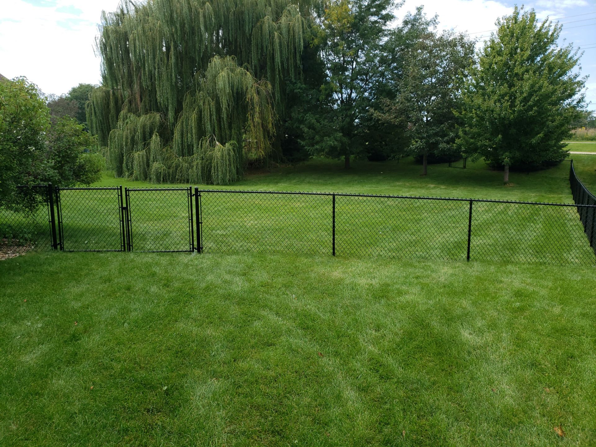 Black Vinyl-Coated Chain Link Fence Installation in Cedar Falls by Perfect Picket Fence and Stain