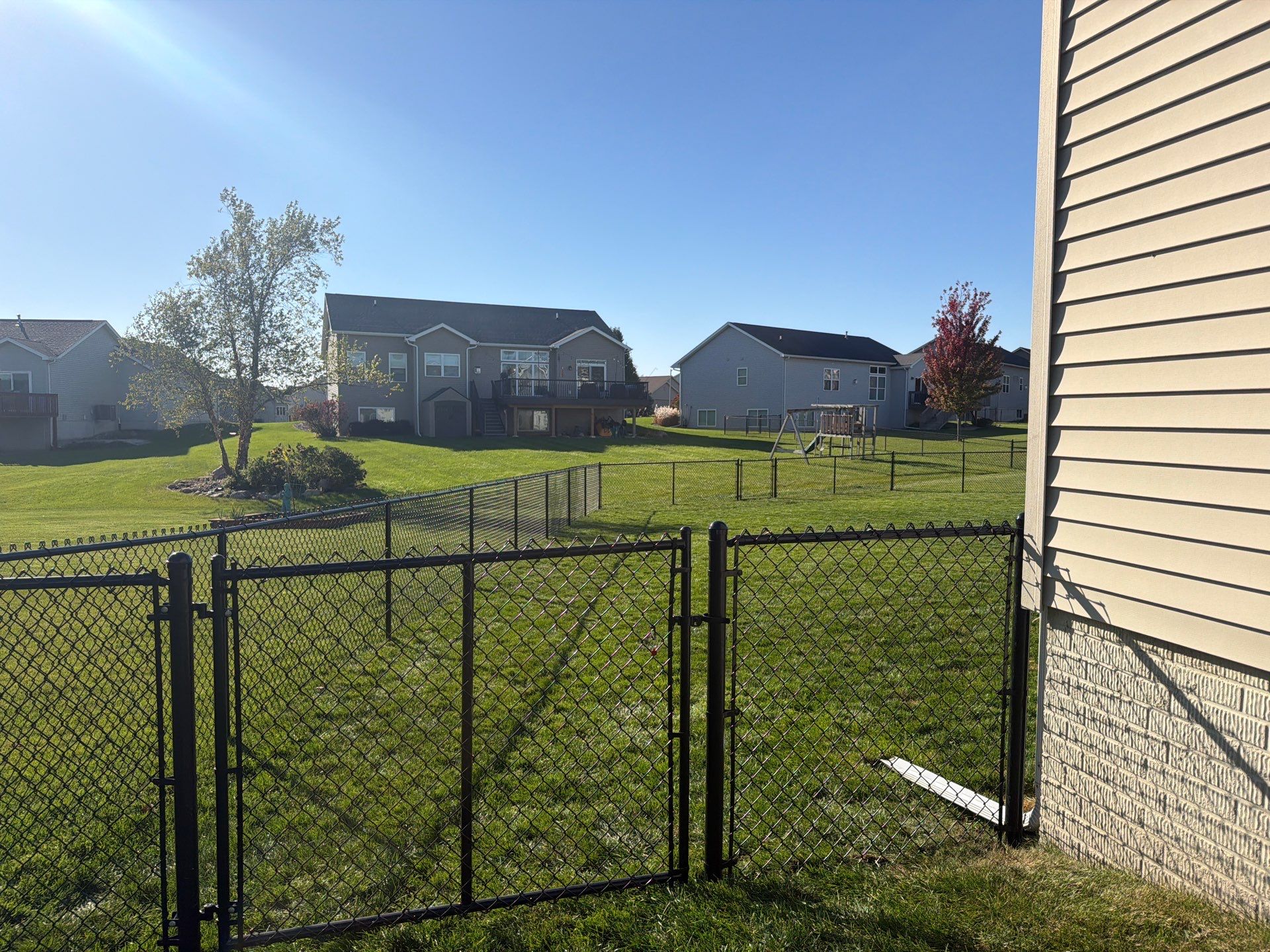 Black Vinyl-Coated Chain Link Fence Installation in Cedar Falls by Perfect Picket Fence and Stain