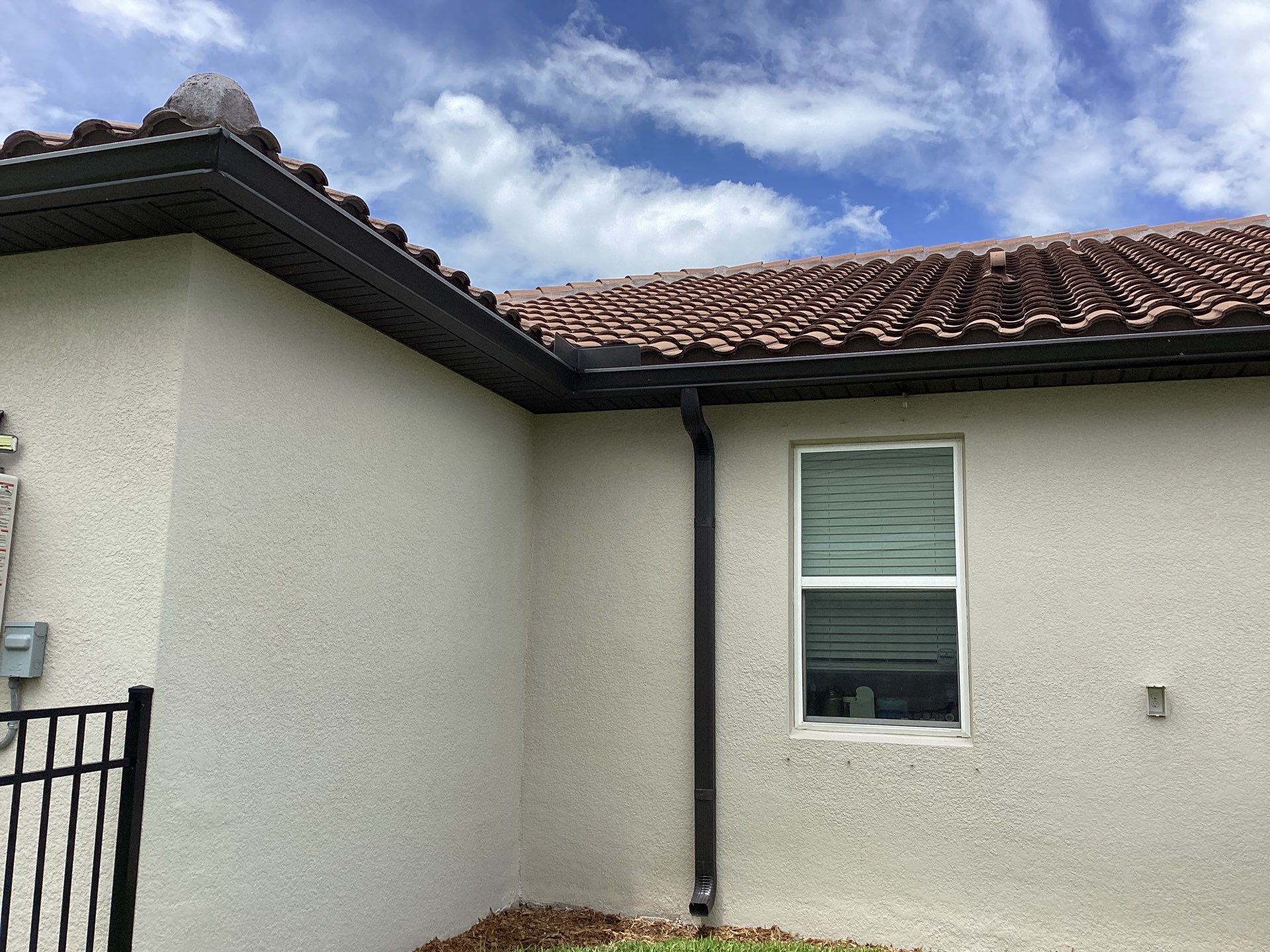 Musket brown seamless gutters with splash guards, new downspouts, and extensions in Bradenton, FL by Gutter Professors