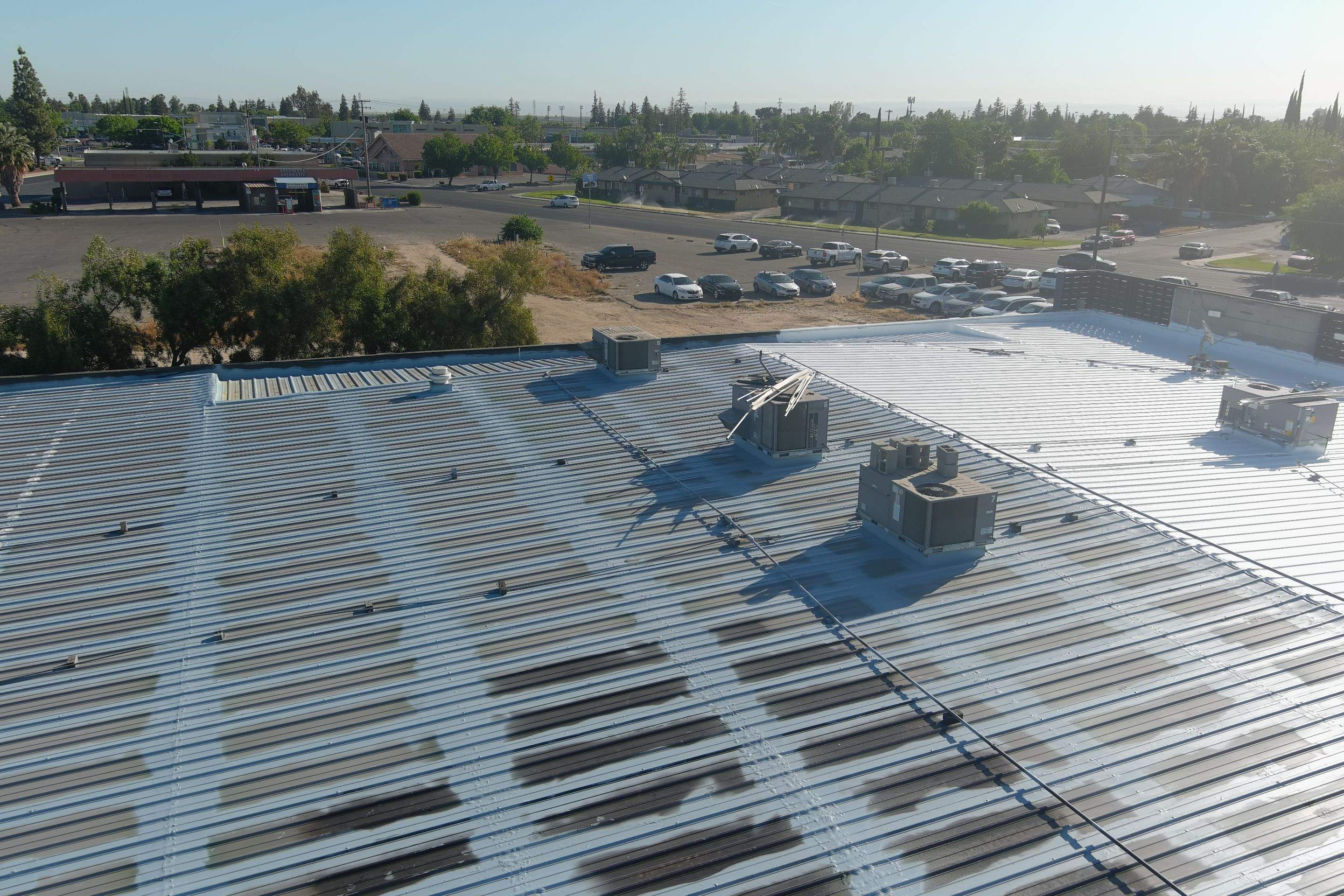 Metal roof restoration on commercial roof using Conklin Benchmark/ PUMA XL acrylic coatings over metal and foam by Straight Edge Roofing Inc