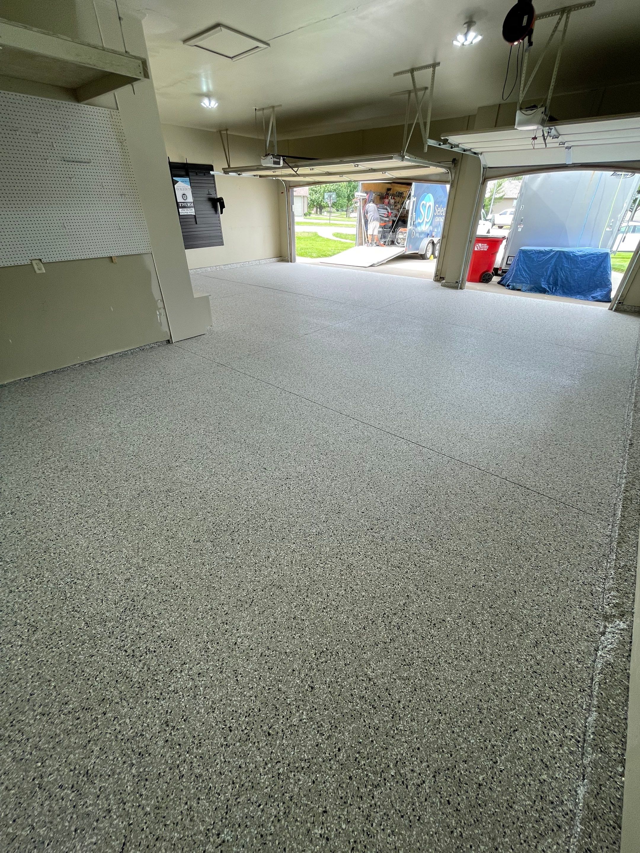 Cabin FEver Flake Garage Floor Coating Installation in Sioux Falls by Select Painting, Coatings & Garage Cabinets