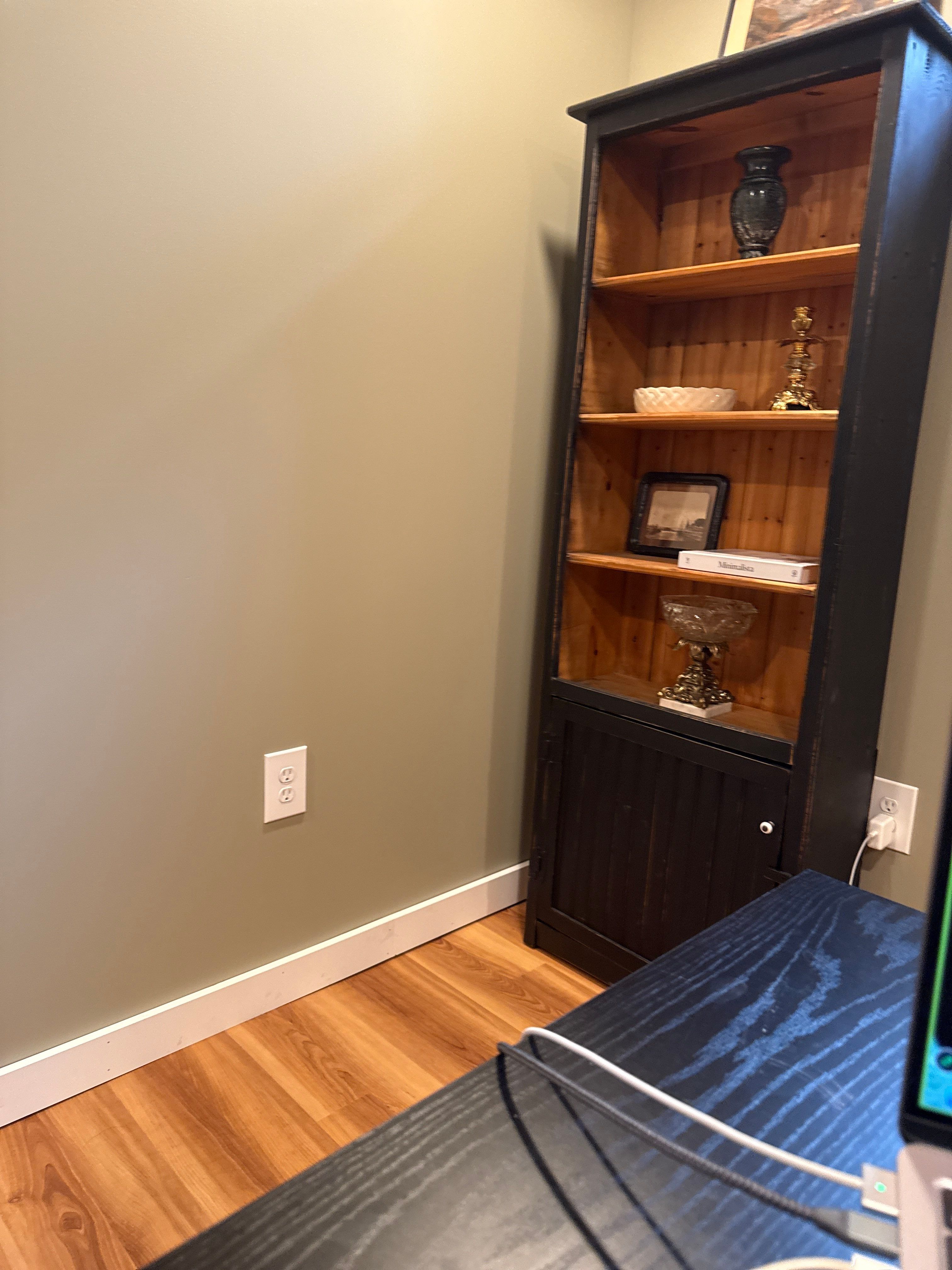 Home Office Setup with Sage Walls and Dark Wood Shelving by CompanyCam Sales Demo