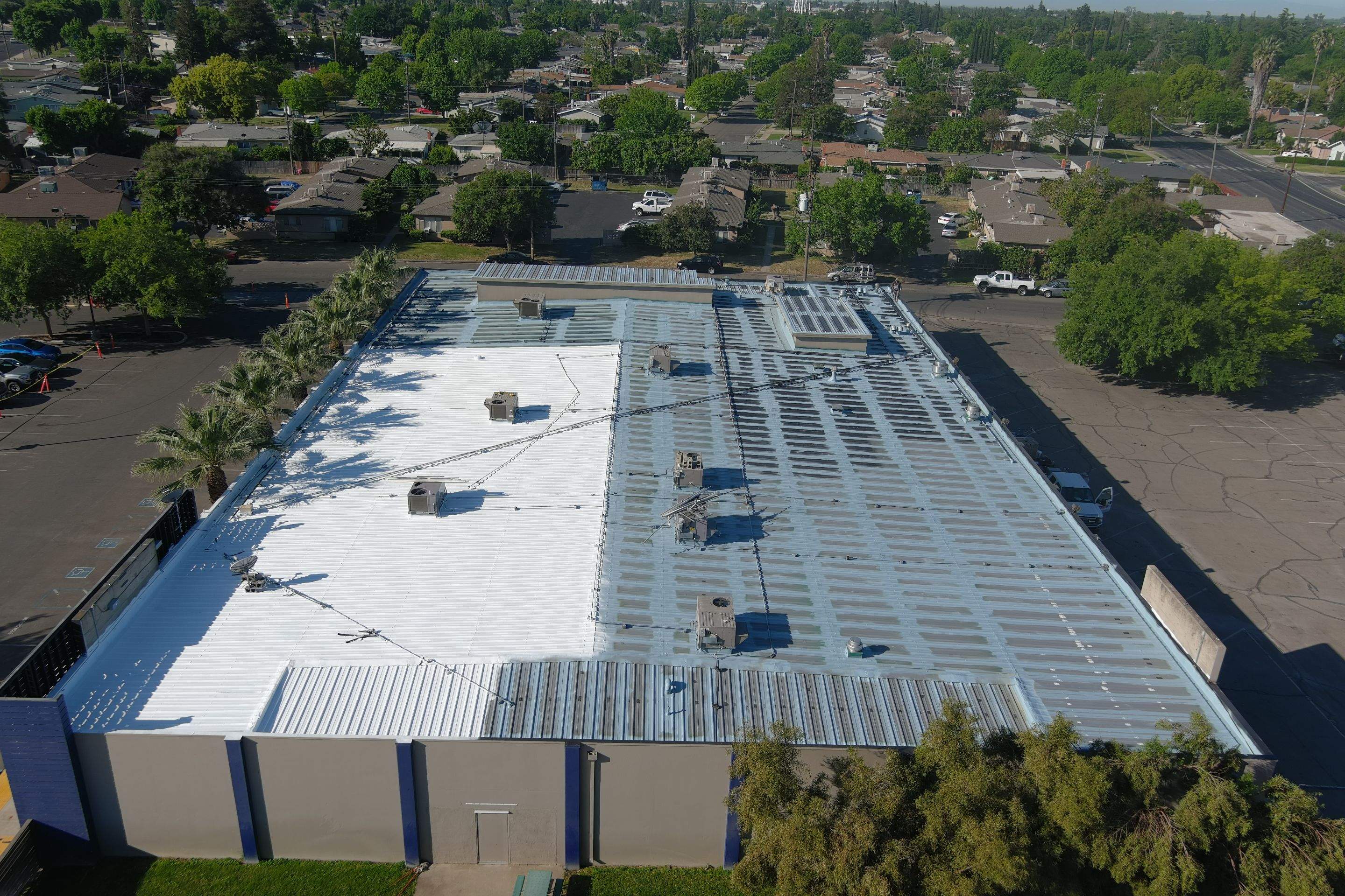 Metal roof restoration on commercial roof using Conklin Benchmark/ PUMA XL acrylic coatings over metal and foam by Straight Edge Roofing Inc