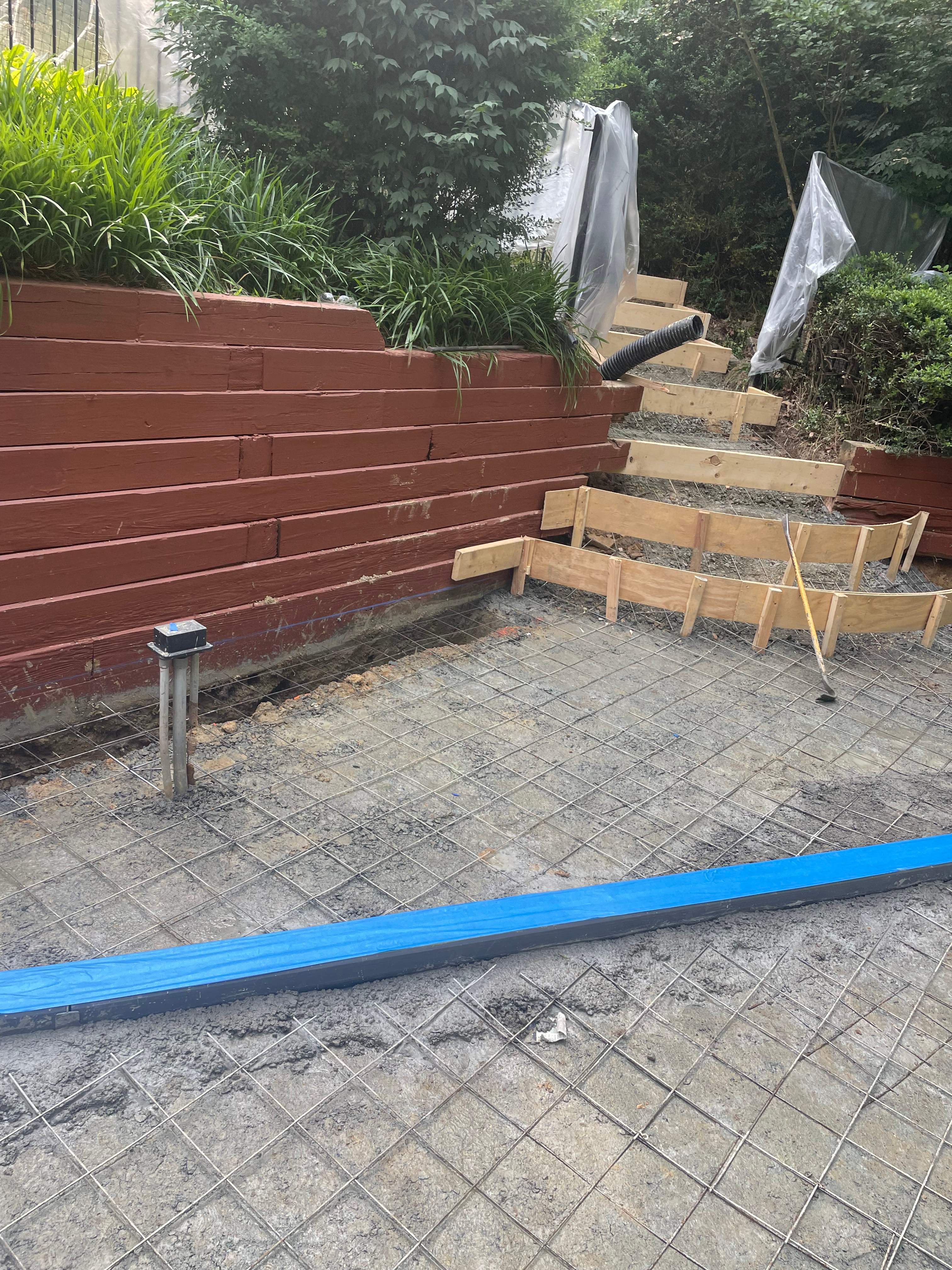 Pool Surround remodel with retaining walls, new waterfall and water slide by Fairfax Contractors, LLC