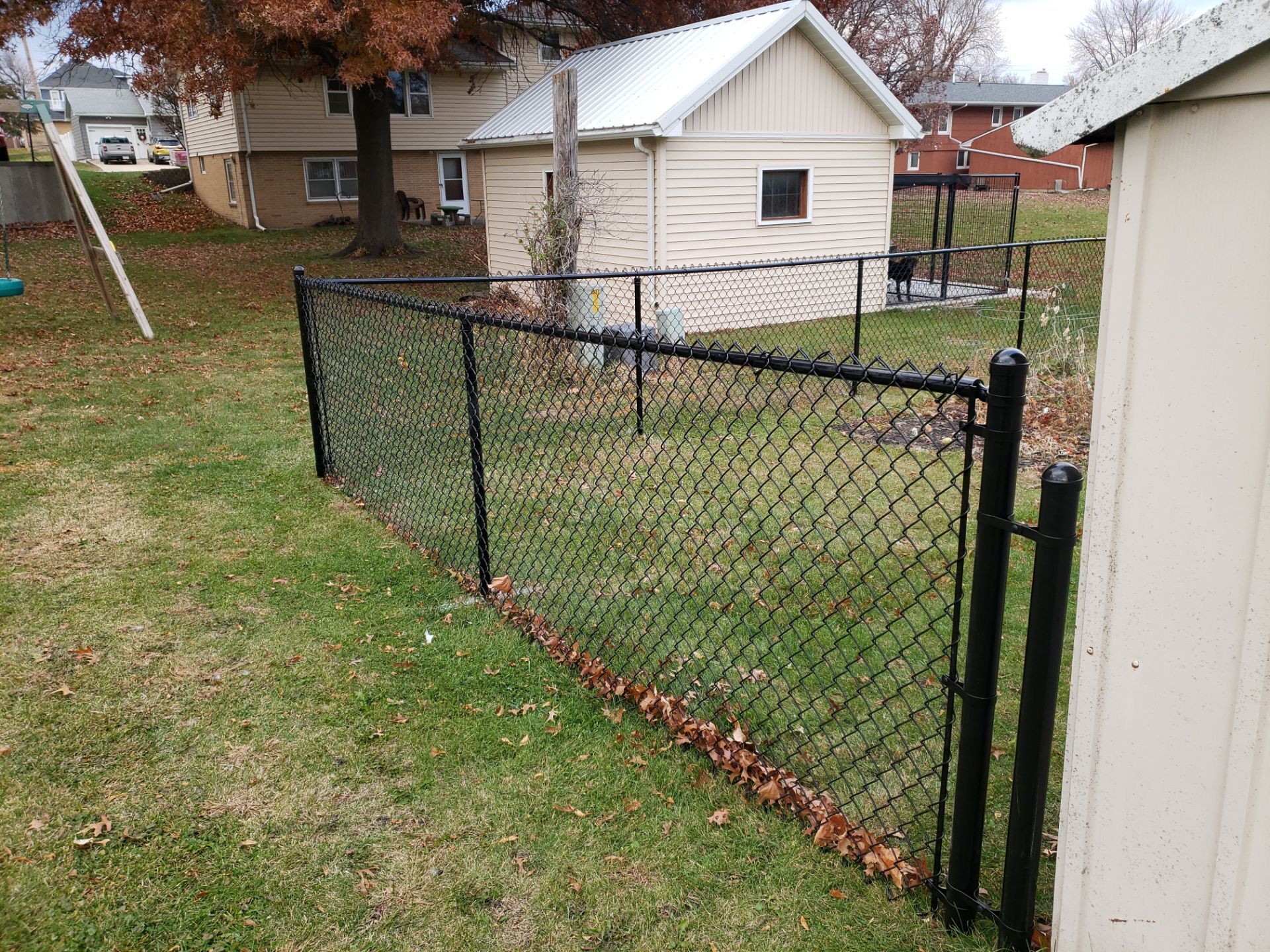 Residential Black Vinyl-Coated Chain Link Fence in Grundy Center by Perfect Picket Fence and Stain