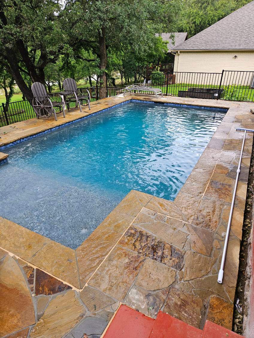 Geometric Pool with Raised Stone Wall and Flagstone Decking by Pinnacle Pools and Spas - DFW