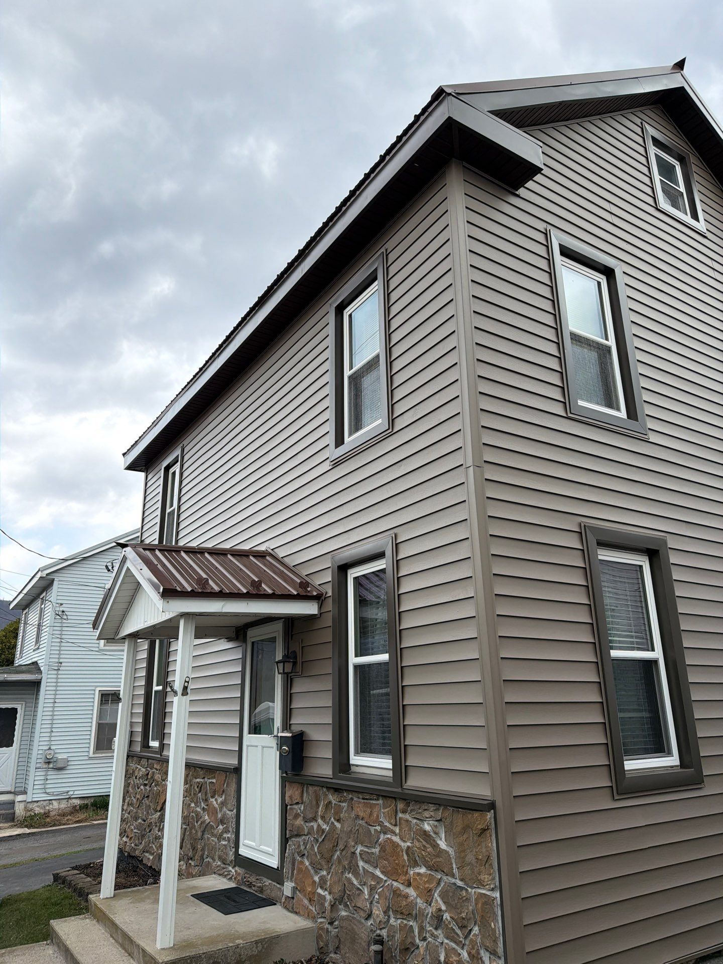 Exterior Renovation with Vinyl Siding, Metal Roof & Spouting  by Esh Builders