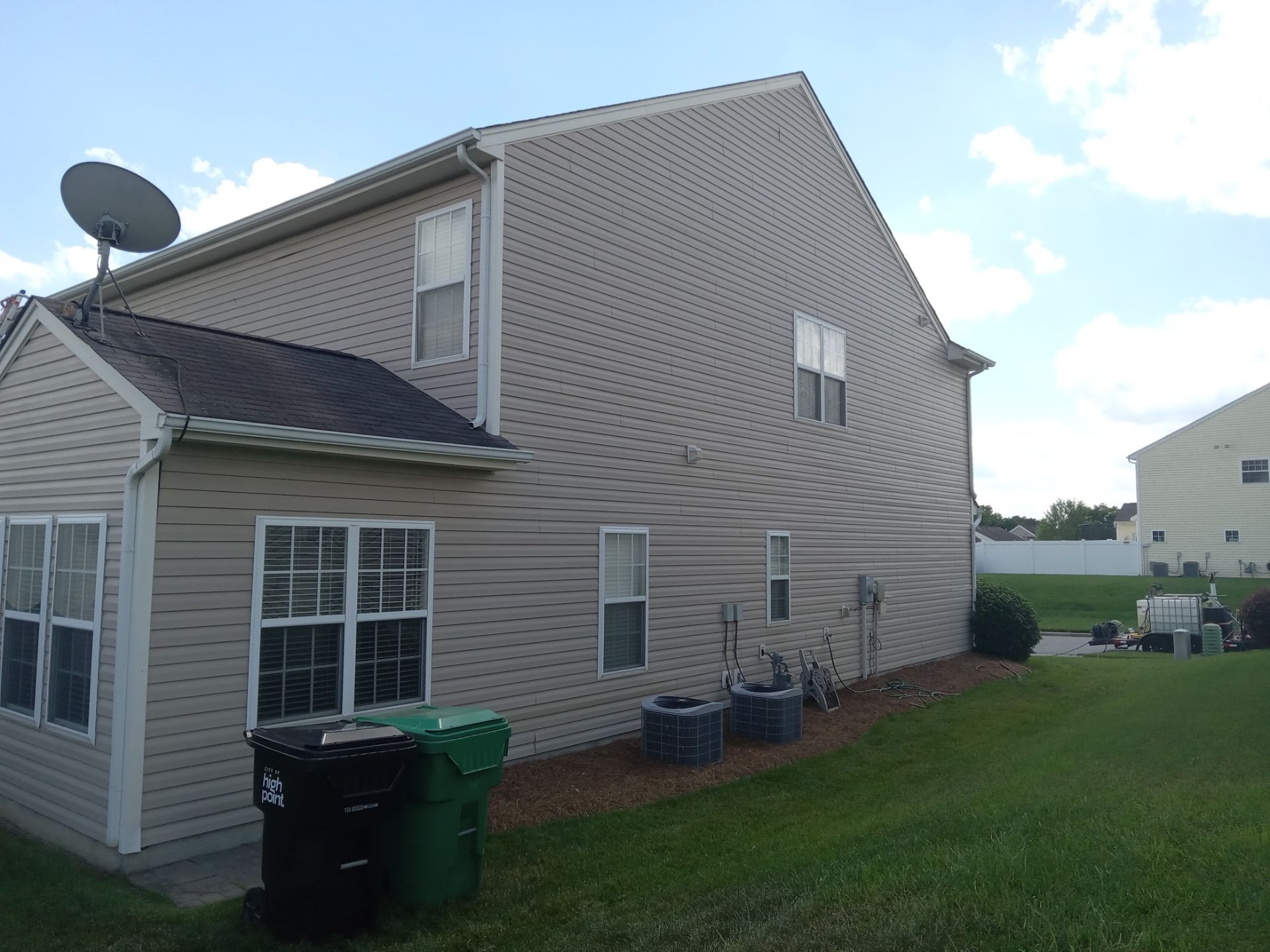 the photo shows a residential house the pressure washing company is likely cleaning the exterior siding of the house to remove dirt grime and mildew from the surfaces the siding appears to be made of vinyl which is a common material that can be effectively cleaned using pressure washing techniques the service may also include cleaning the gutters downspouts and the windows to ensure a comprehensive exterior clean the equipment needed for this job typically includes a high-pressure water machine and various nozzles to suit different surfaces and dirt levels