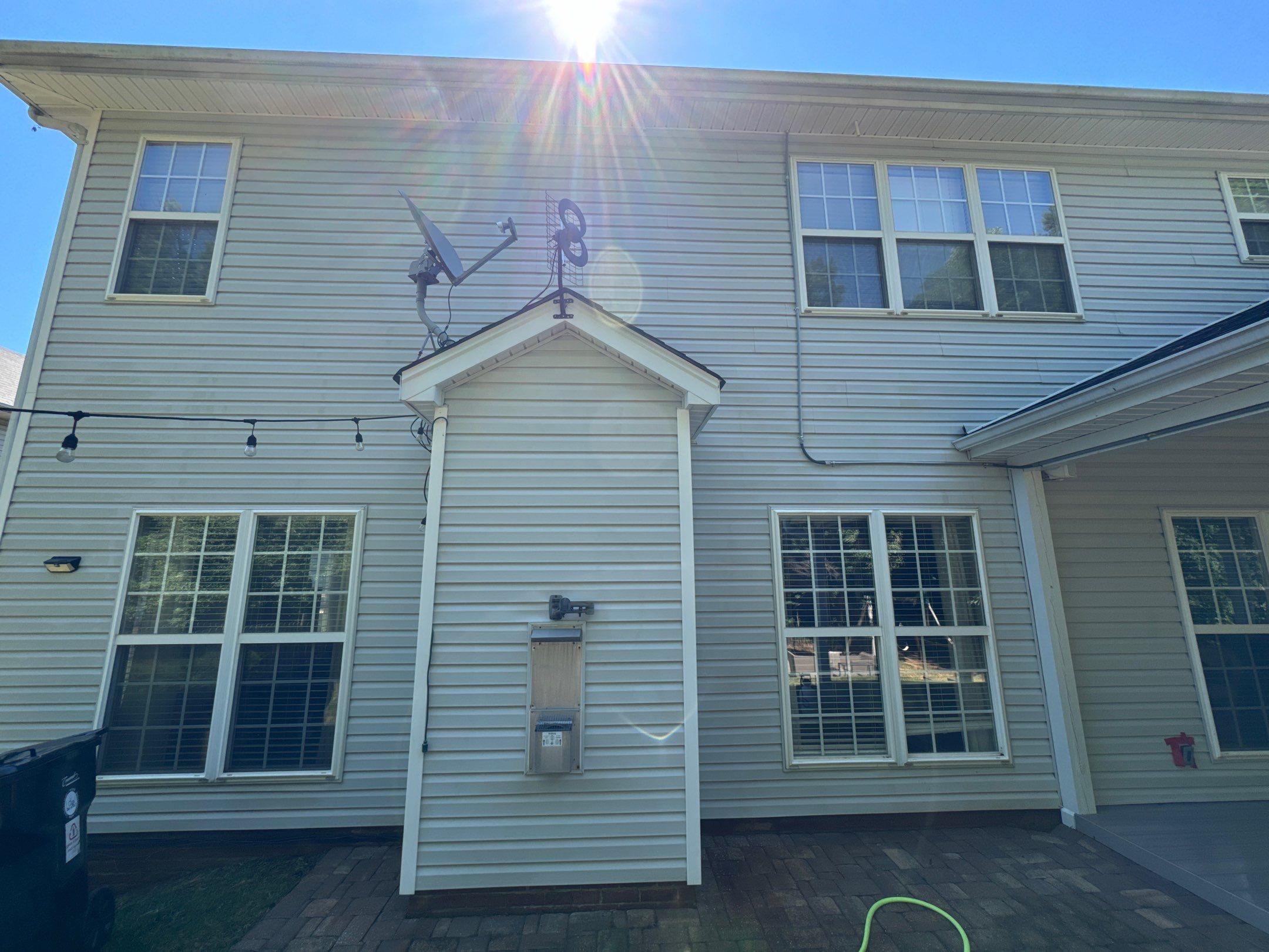 pressure washing company cleaning exterior house siding and paved patio in winston salem nc