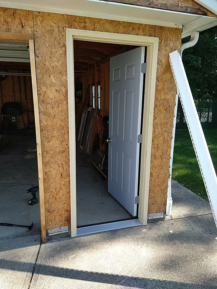Siding Installation using Norandex woodsman dl-5 white woodgrain vinyl by Absolute Roofing and Construction