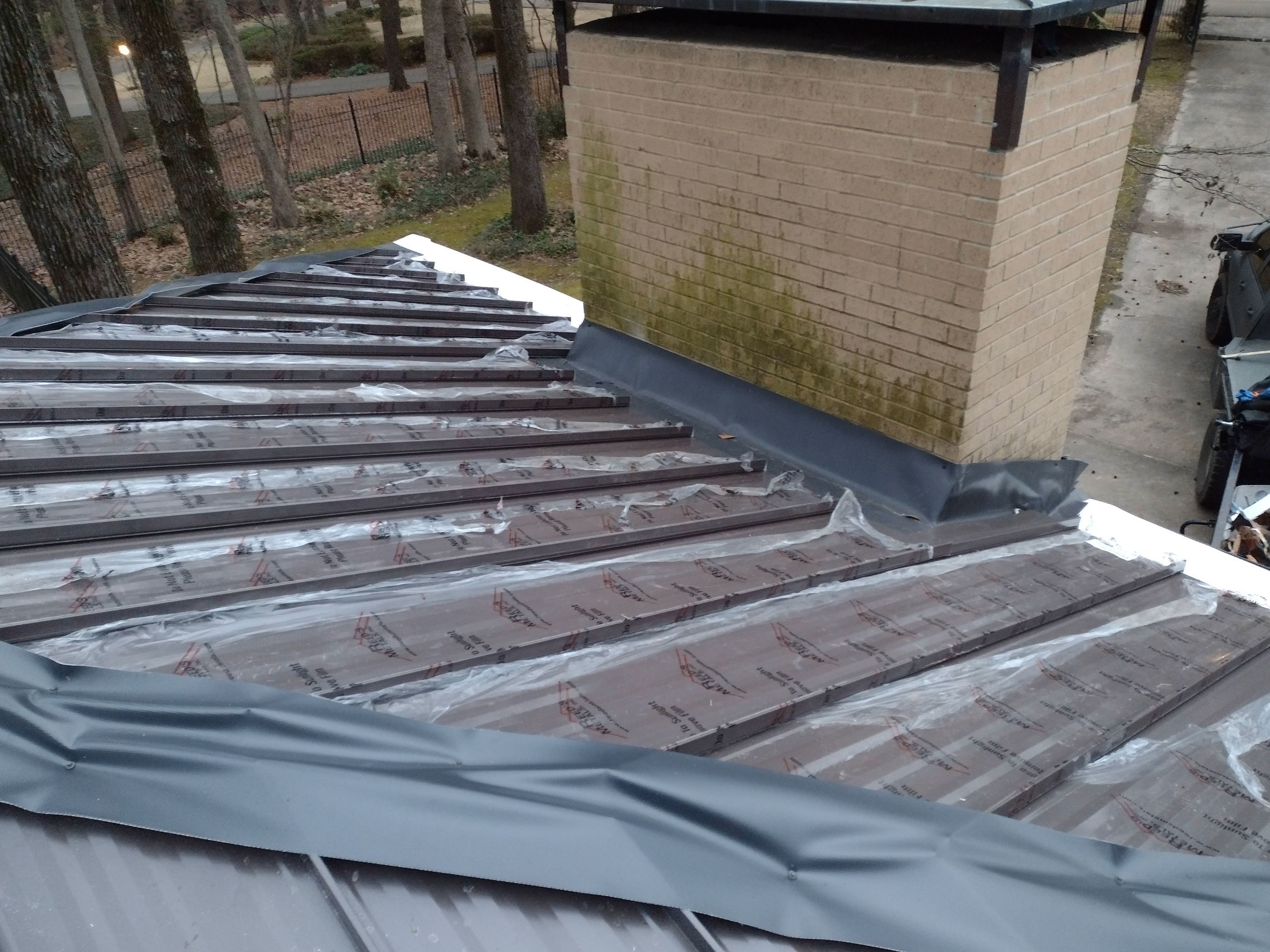 Residential Roofing Installation using PVC membrane and 24 gauge Standing Seam Metal by Hostetler Roofing