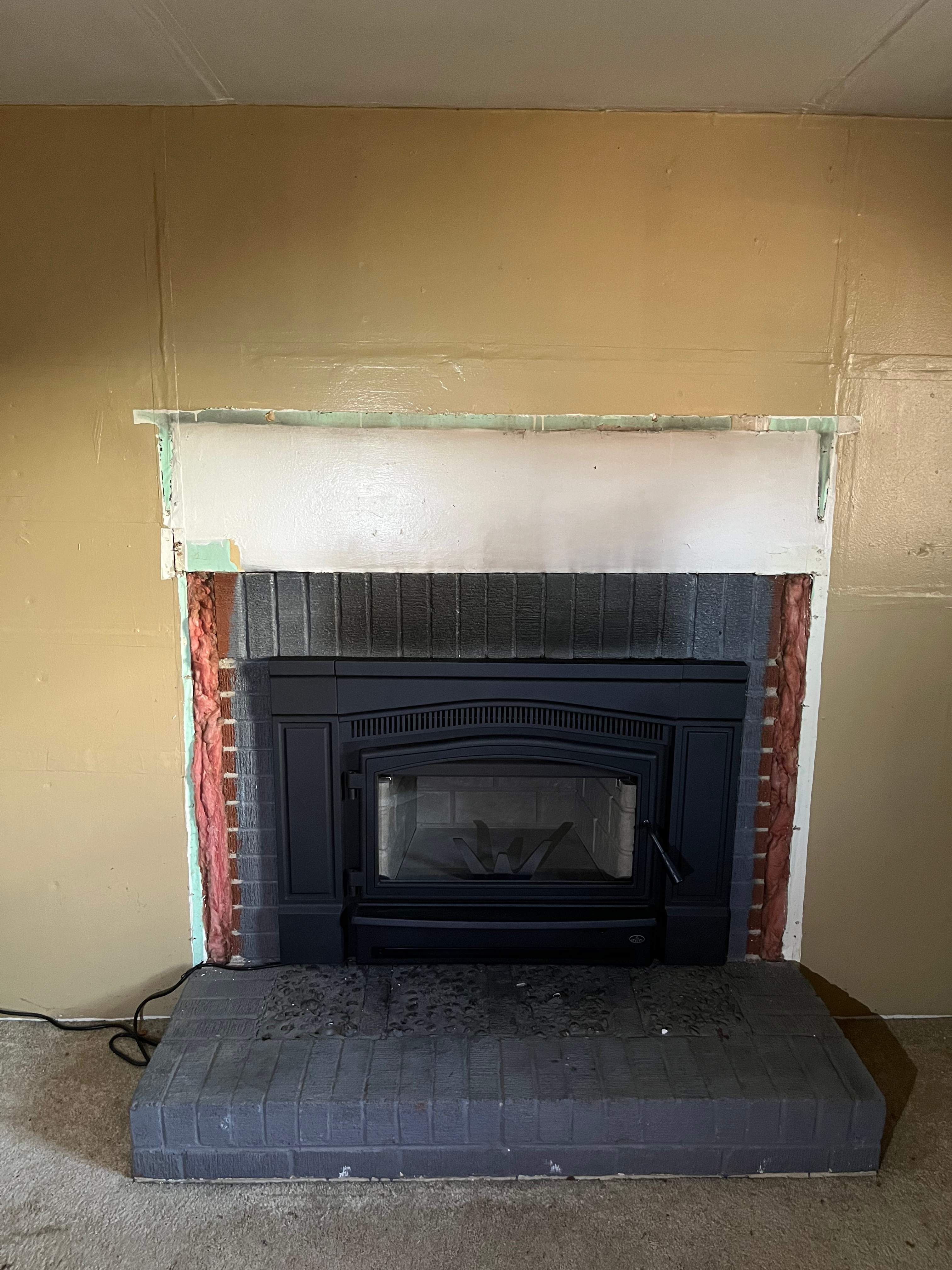 Wood Stove Insert + Stone + Mantel by Premier Chimney and Roofing