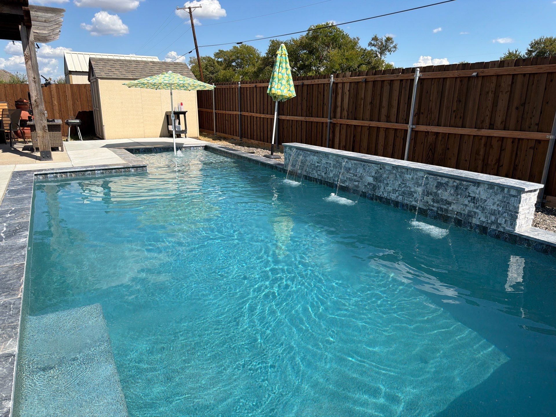 Geometric Pool with Raised Stone Waterfall Wall by Pinnacle Pools and Spas - DFW