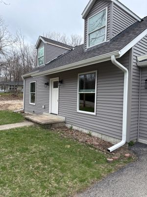 White Seamless Gutter and Downspout Installation in Charlevoix