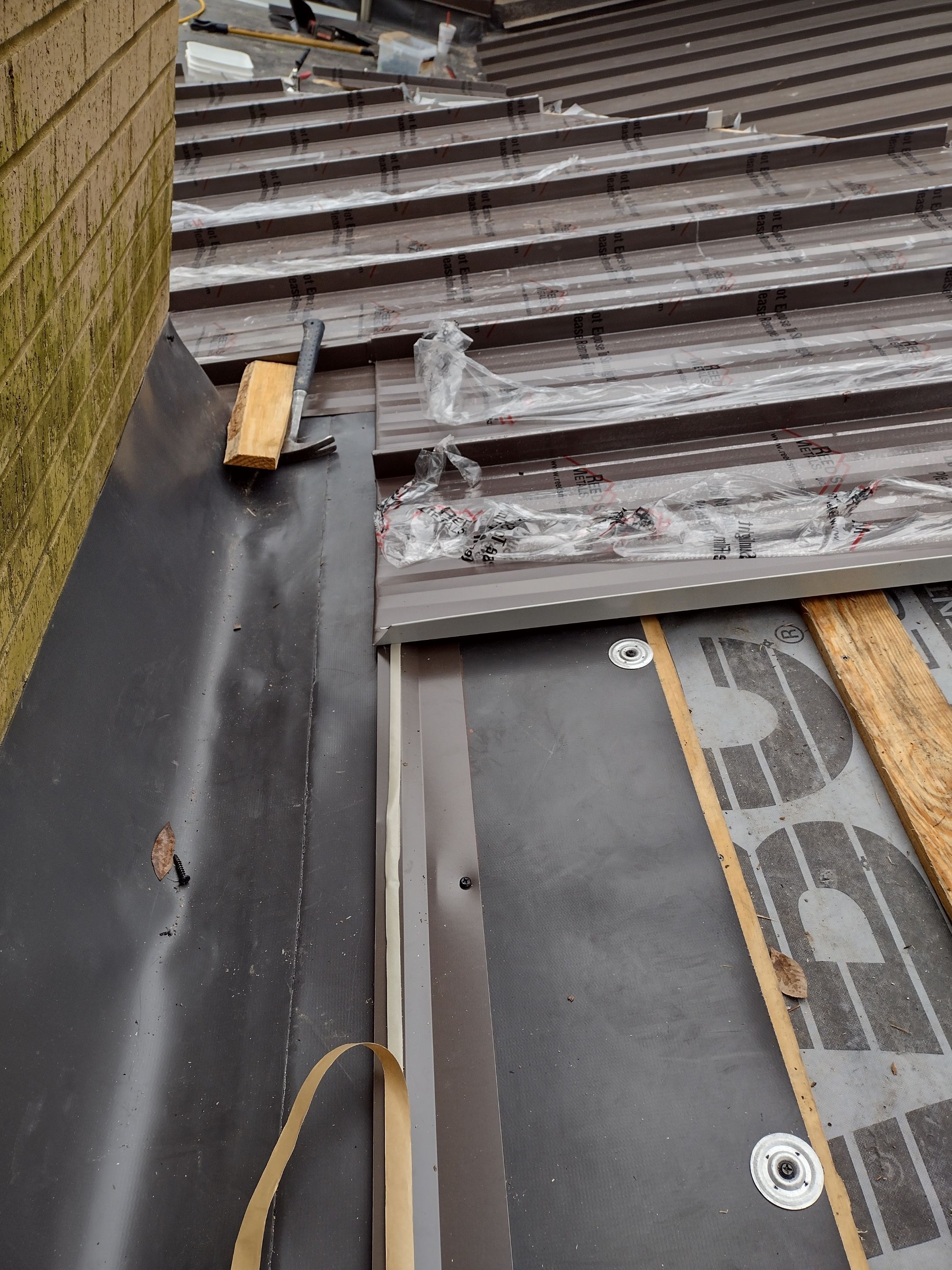Residential Roofing Installation using PVC membrane and 24 gauge Standing Seam Metal by Hostetler Roofing
