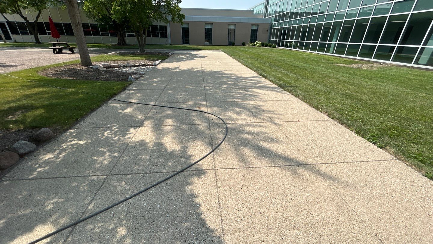 concrete using Algaecide, soft wash soap by Northern Power Washing LLC.