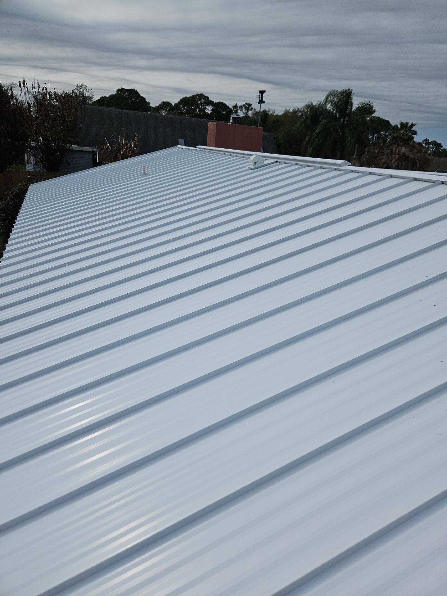 White Standing Seam Metal Roof Replacement and Hurricane Reinforcement in Palm Bay, Florida by Wiedmann Construction & Roofing